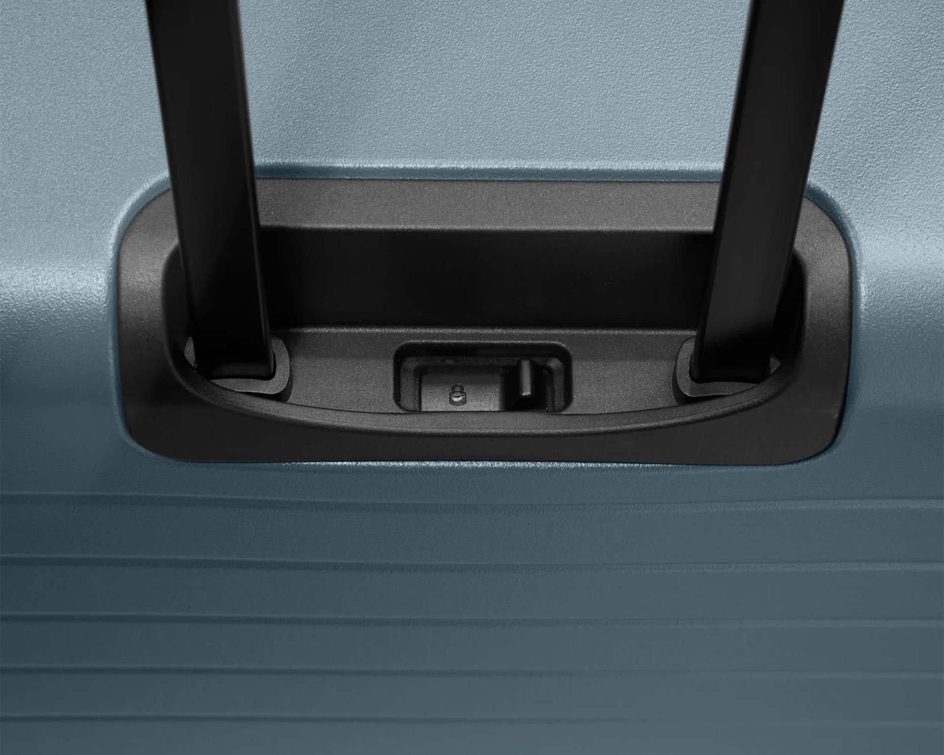 Close-up of black suitcase handle slots set in a textured blue hard shell.