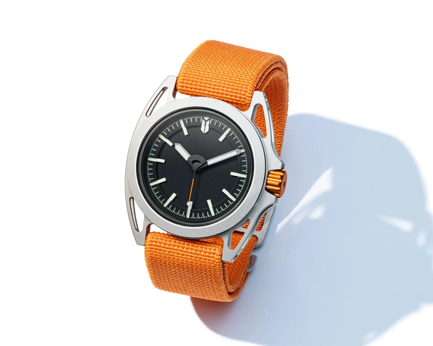 Watch with a black dial, silver case, orange crown, and orange fabric strap on a white background.