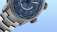 Close-up of a stainless steel wristwatch with a blue dial featuring world city names and a date window.