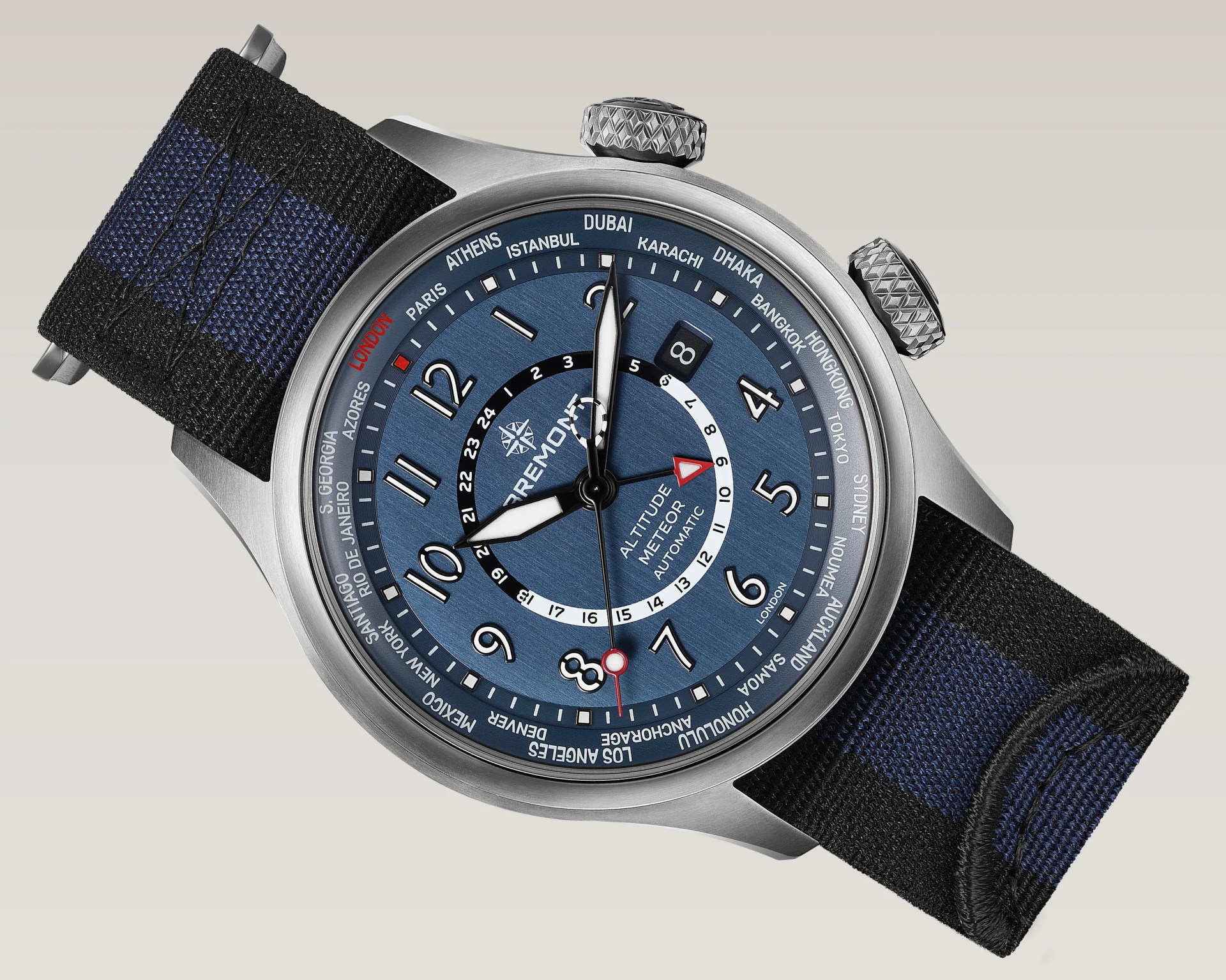 Blue dial Bremont Altitude Meteor automatic watch with black and blue fabric strap and city names on the bezel.