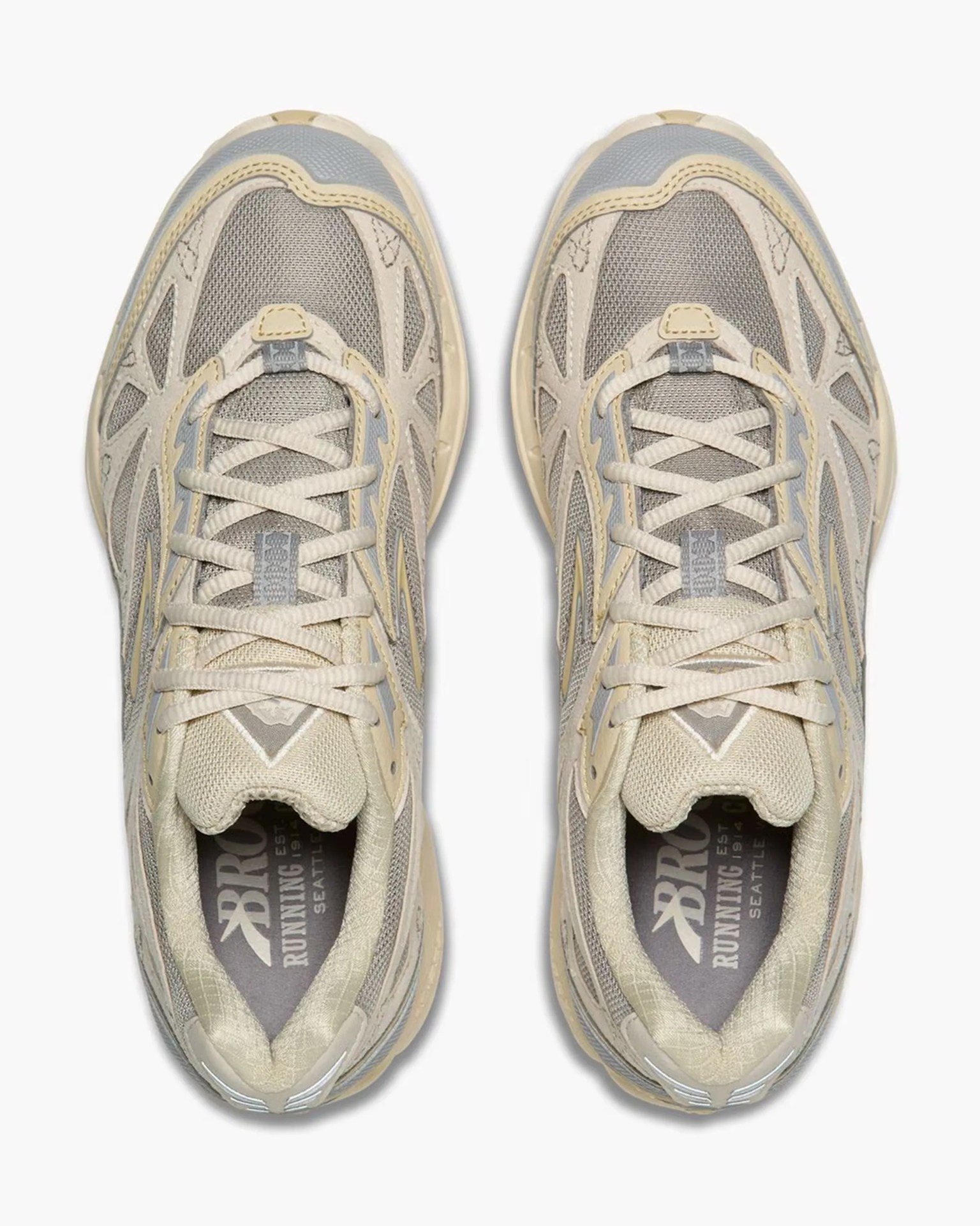 Top view of beige and gray mesh running shoes with cream laces and "Brooks Running" insoles.