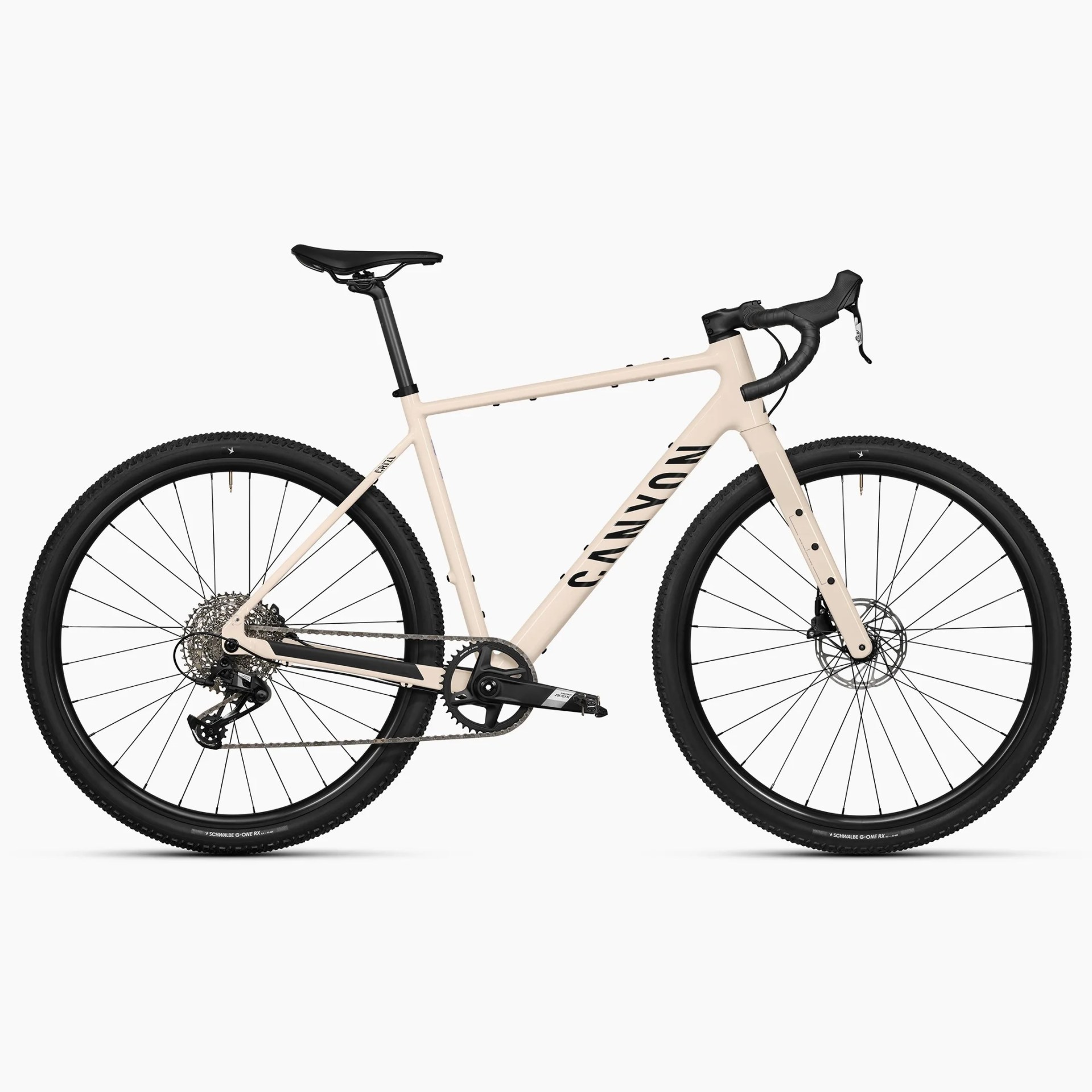 Beige Canyon gravel bike with black saddle, drop handlebars, and knobby tires.