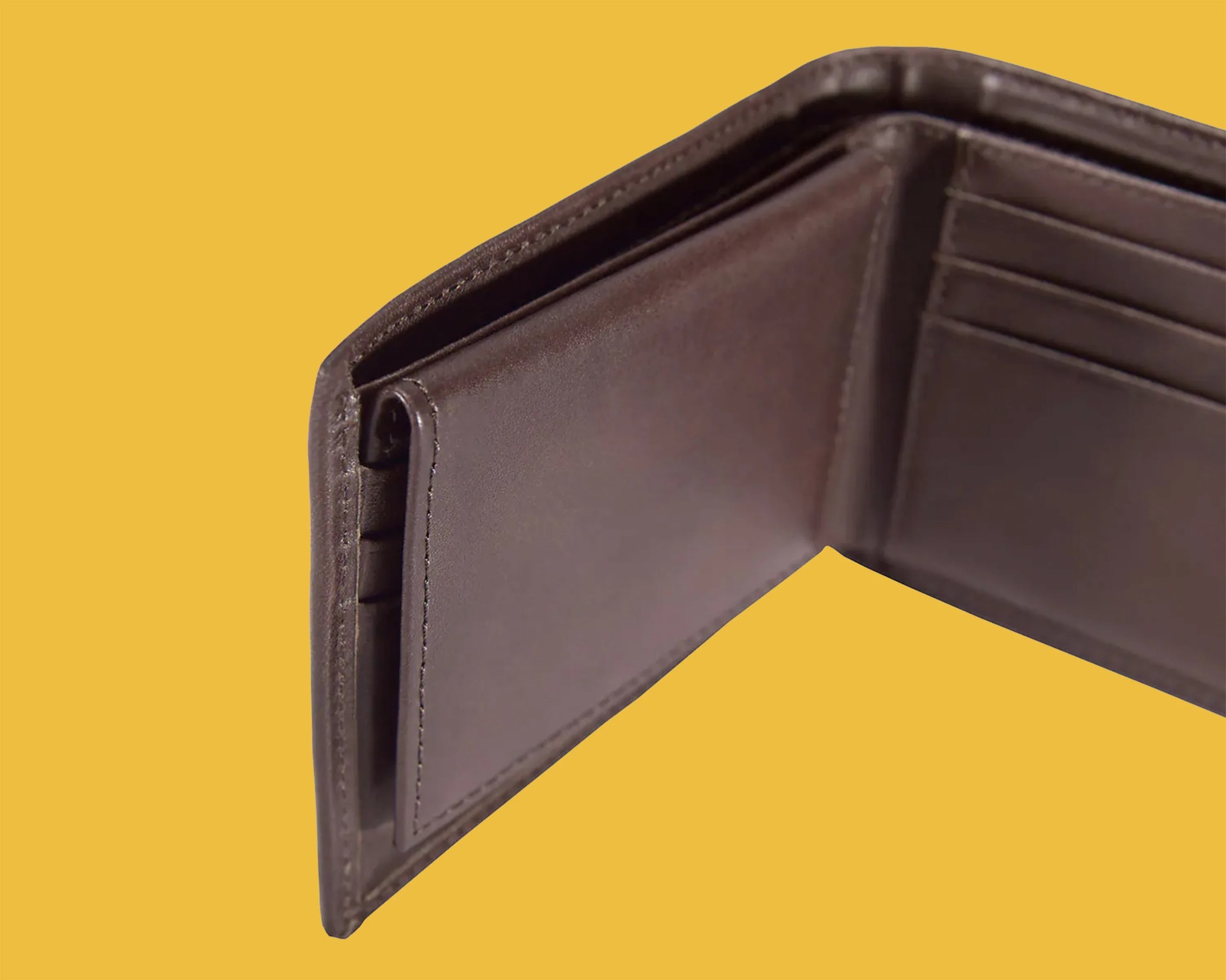 Brown leather bifold wallet open against a yellow background.