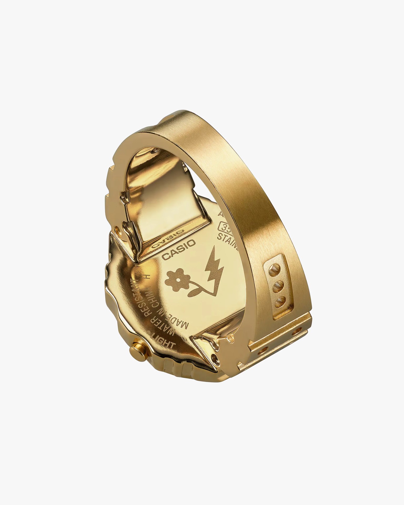 Gold-toned metal watch backplate with Casio branding and a flower and lightning bolt symbol.