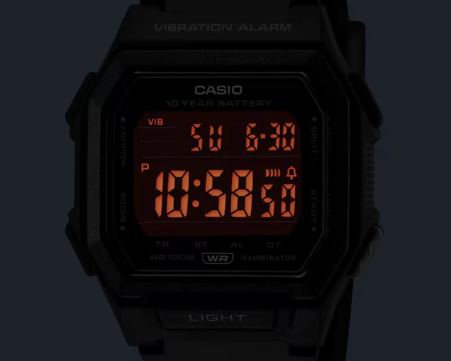 Black Casio digital watch with orange backlit display showing time, date, and alarm icons.