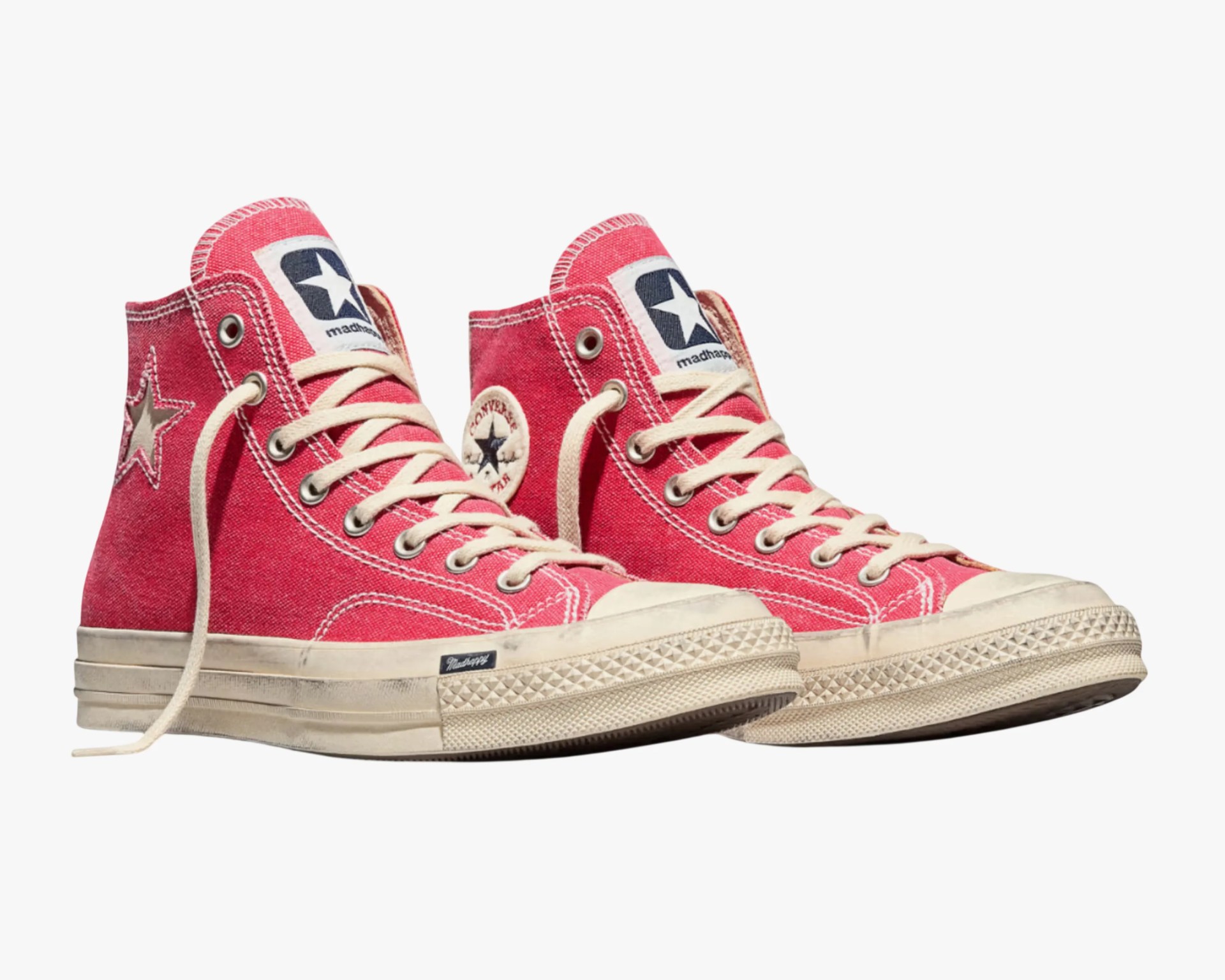 Pair of red high-top canvas sneakers with white laces, white rubber soles, and star logos on the sides.