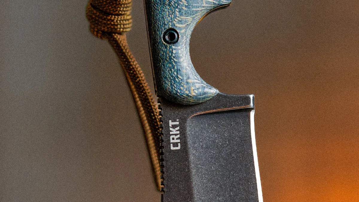 Close-up of a CRKT knife blade with a textured blue handle and a brown cord attached.