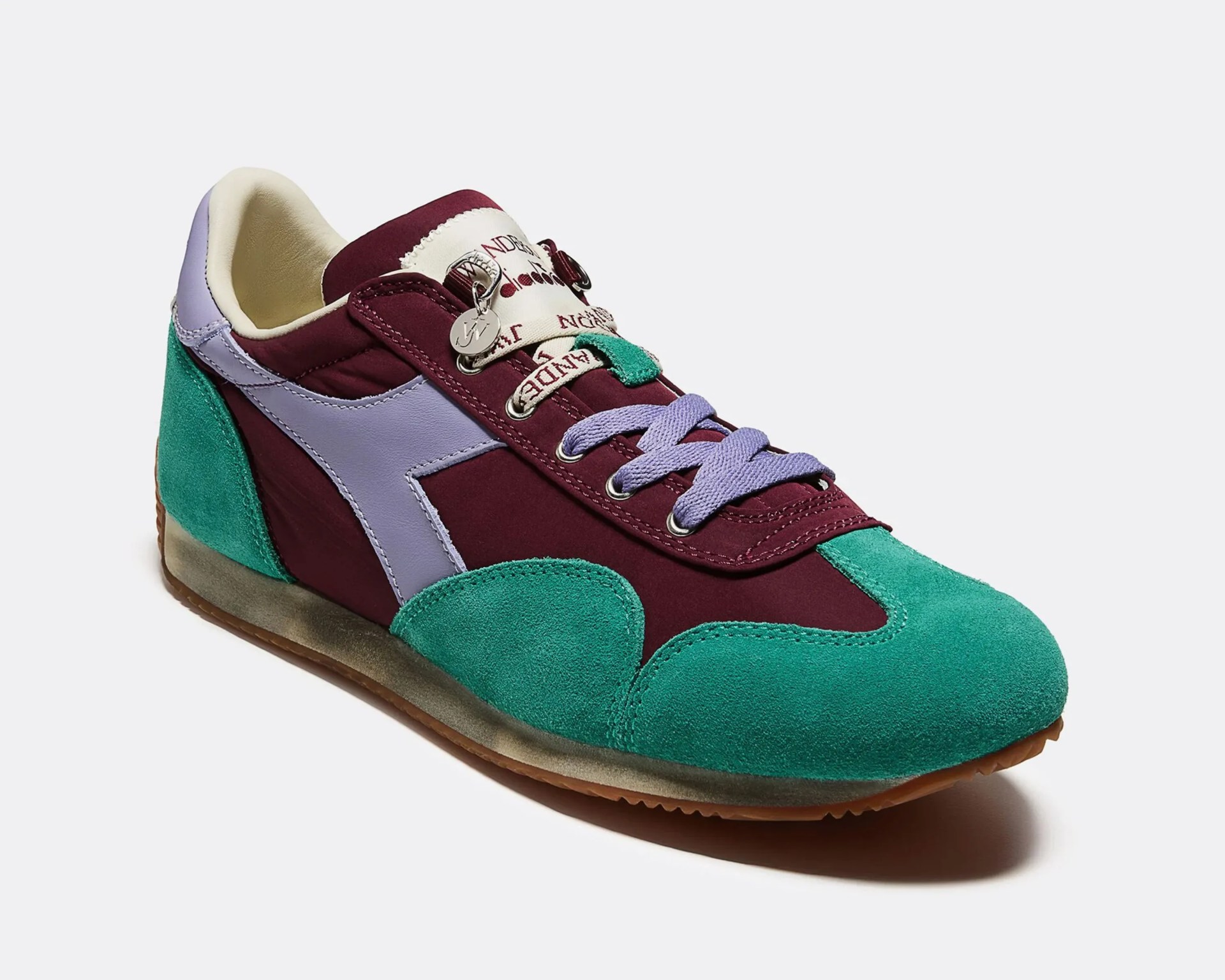 Sneaker with teal suede toe and heel, burgundy fabric upper, lavender leather side stripe, and lavender laces.