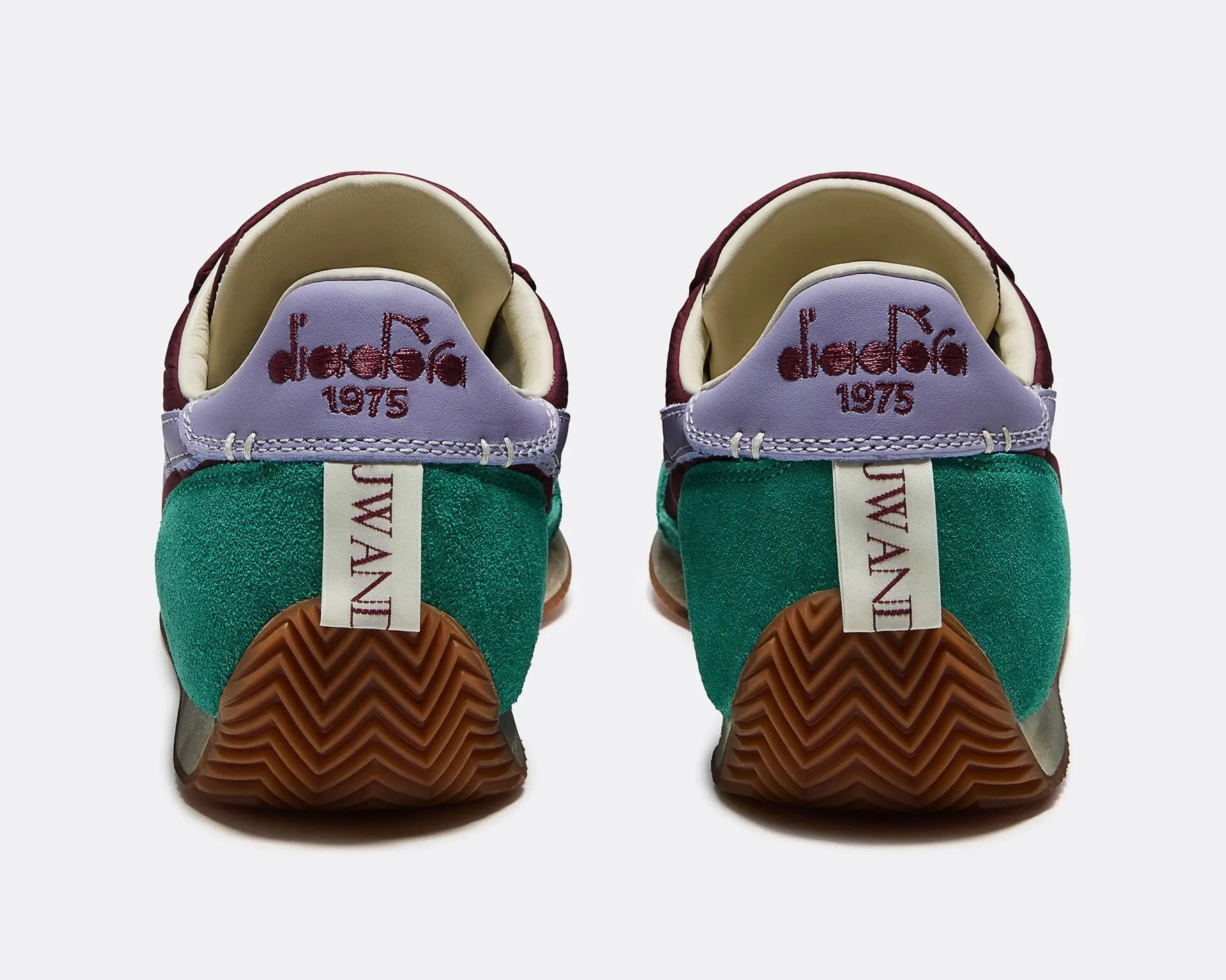 Pair of sneakers with green suede heels, purple leather collars embroidered with "diadora 1975," and brown rubber soles.