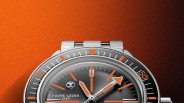 Close-up of a Favre-Leuba 1737 wristwatch with a black dial, orange accents, and a silver metal bracelet.