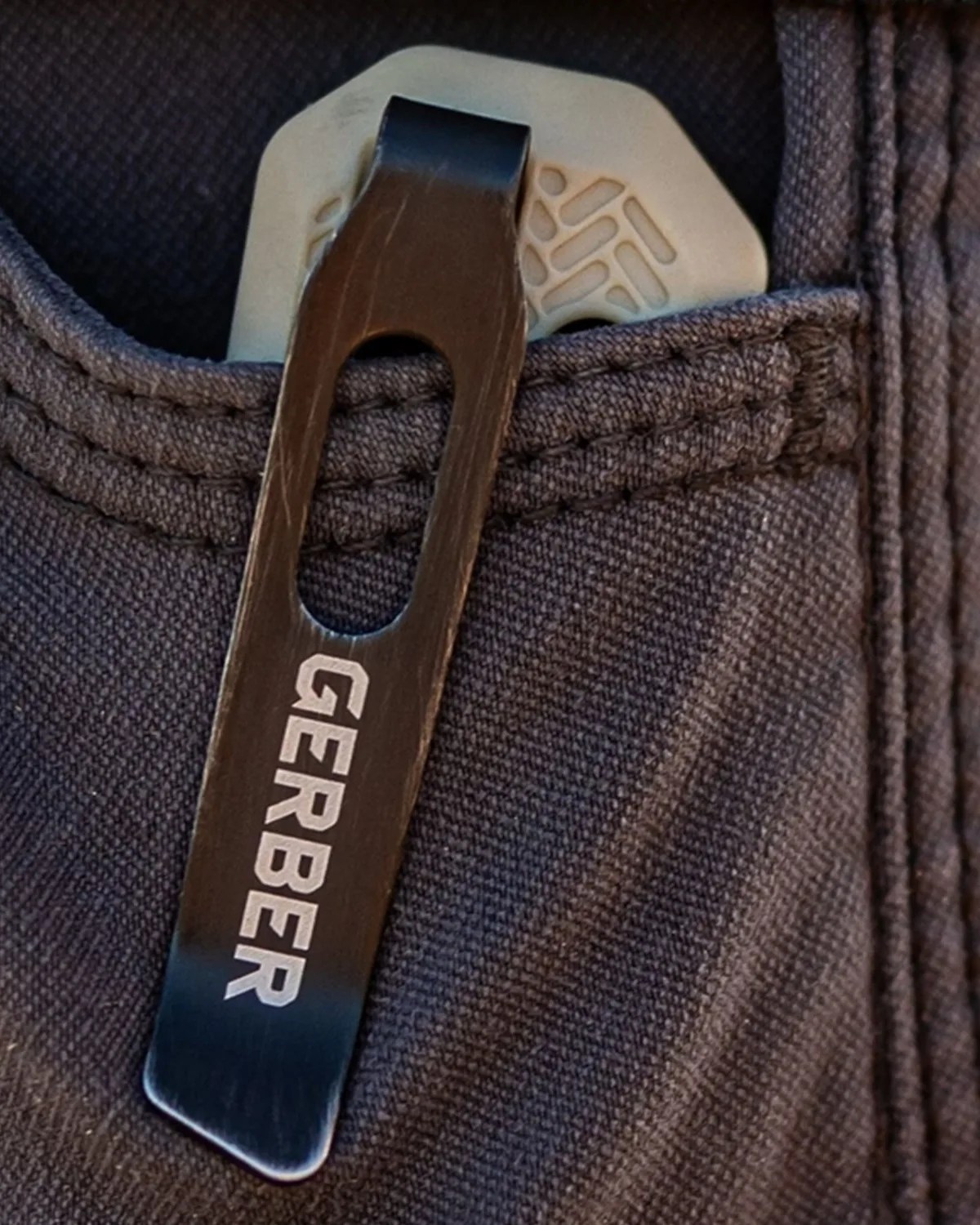 Black metal Gerber pocket clip attached to dark fabric pocket edge.