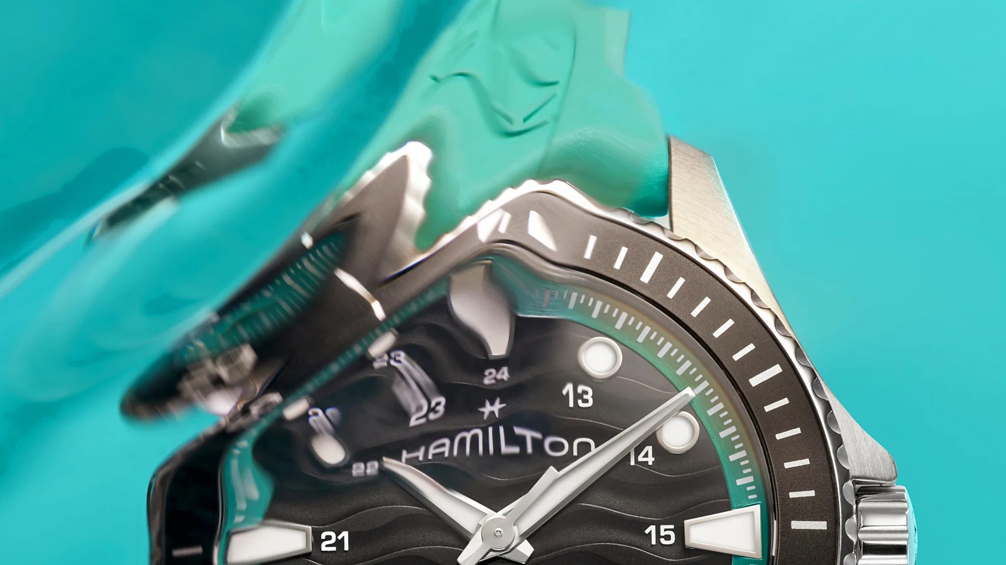 Close-up of a Hamilton watch face with black dial, white markers, and silver bezel partially distorted by water.