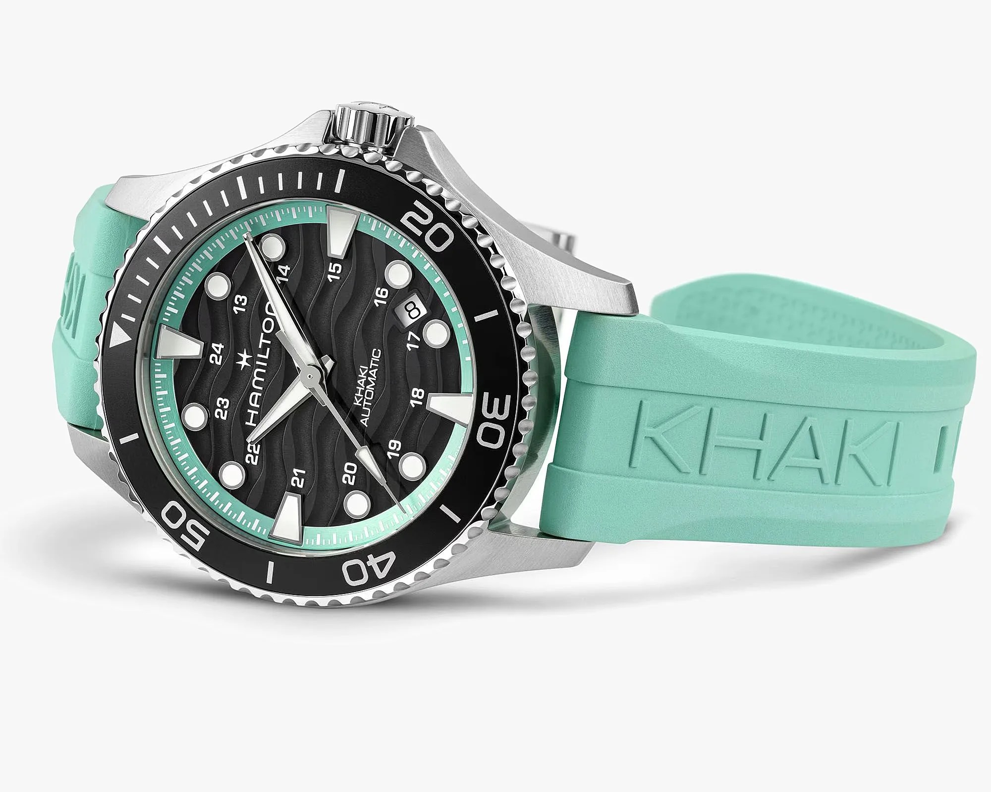 Silver Hamilton Khaki Automatic watch with black dial, wave pattern, date window, and turquoise rubber strap.