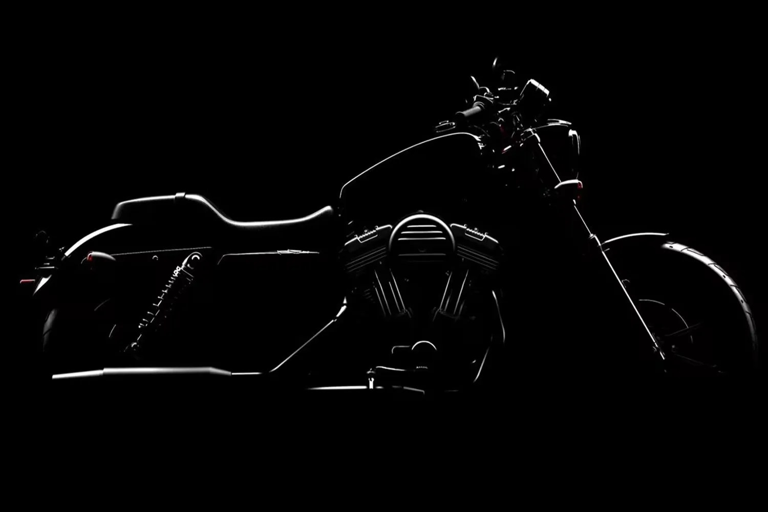 Side view of a motorcycle with illuminated edges highlighting the seat, fuel tank, engine, and front wheel against a black background.