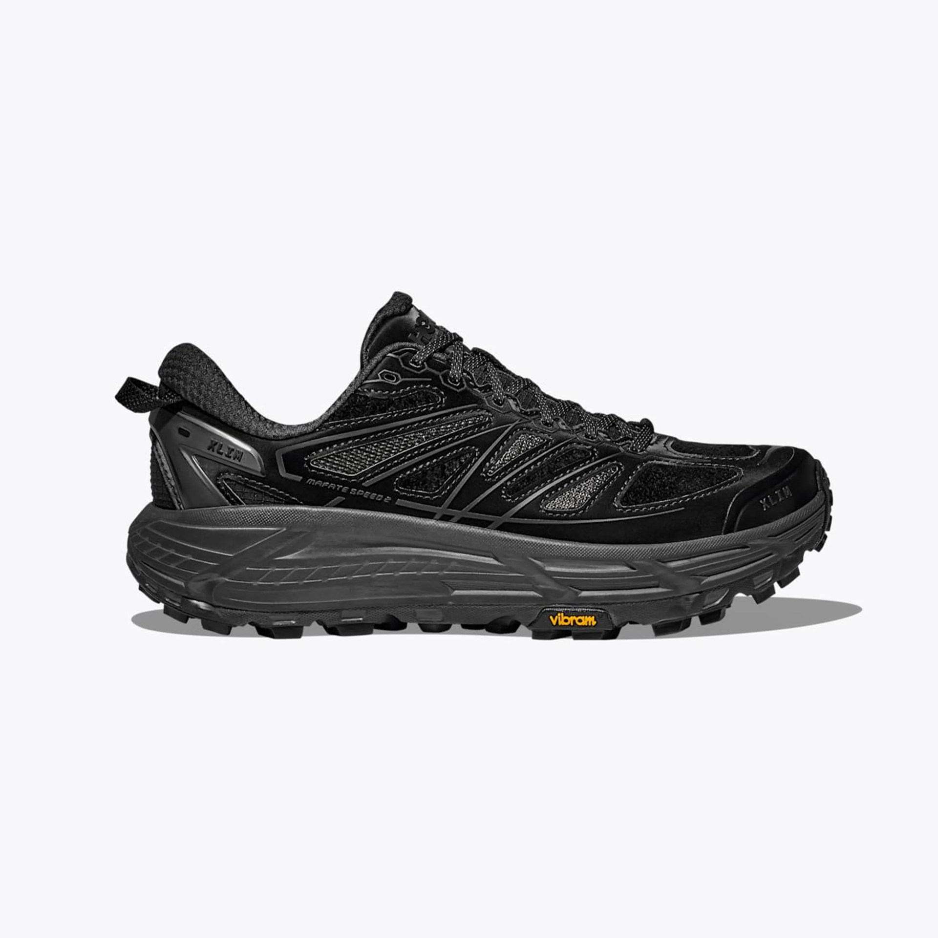 Black trail running shoe with mesh and synthetic upper, thick sole, and Vibram logo on the outsole.