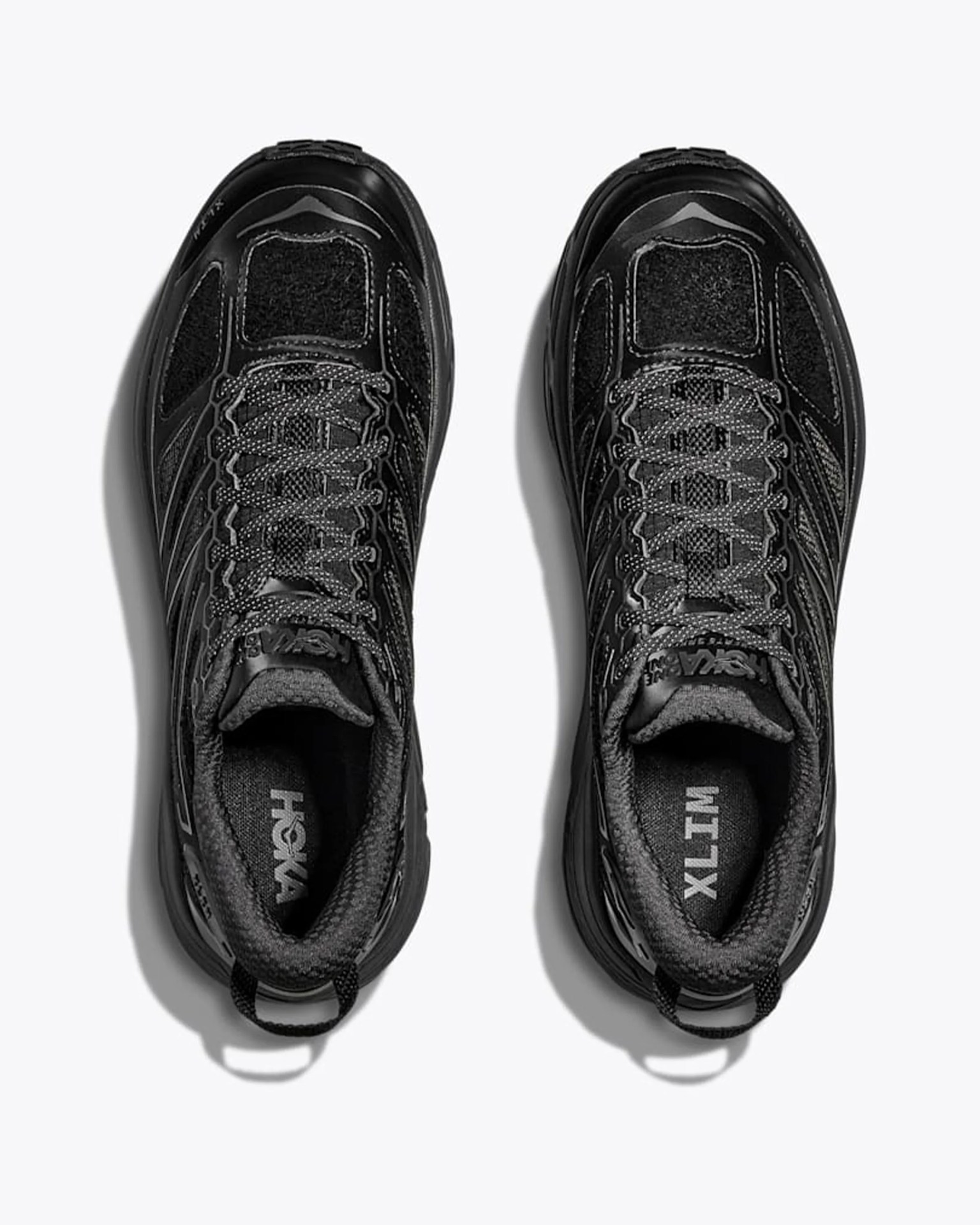 Pair of black Hoka XLT running shoes with gray laces viewed from above on a white background.
