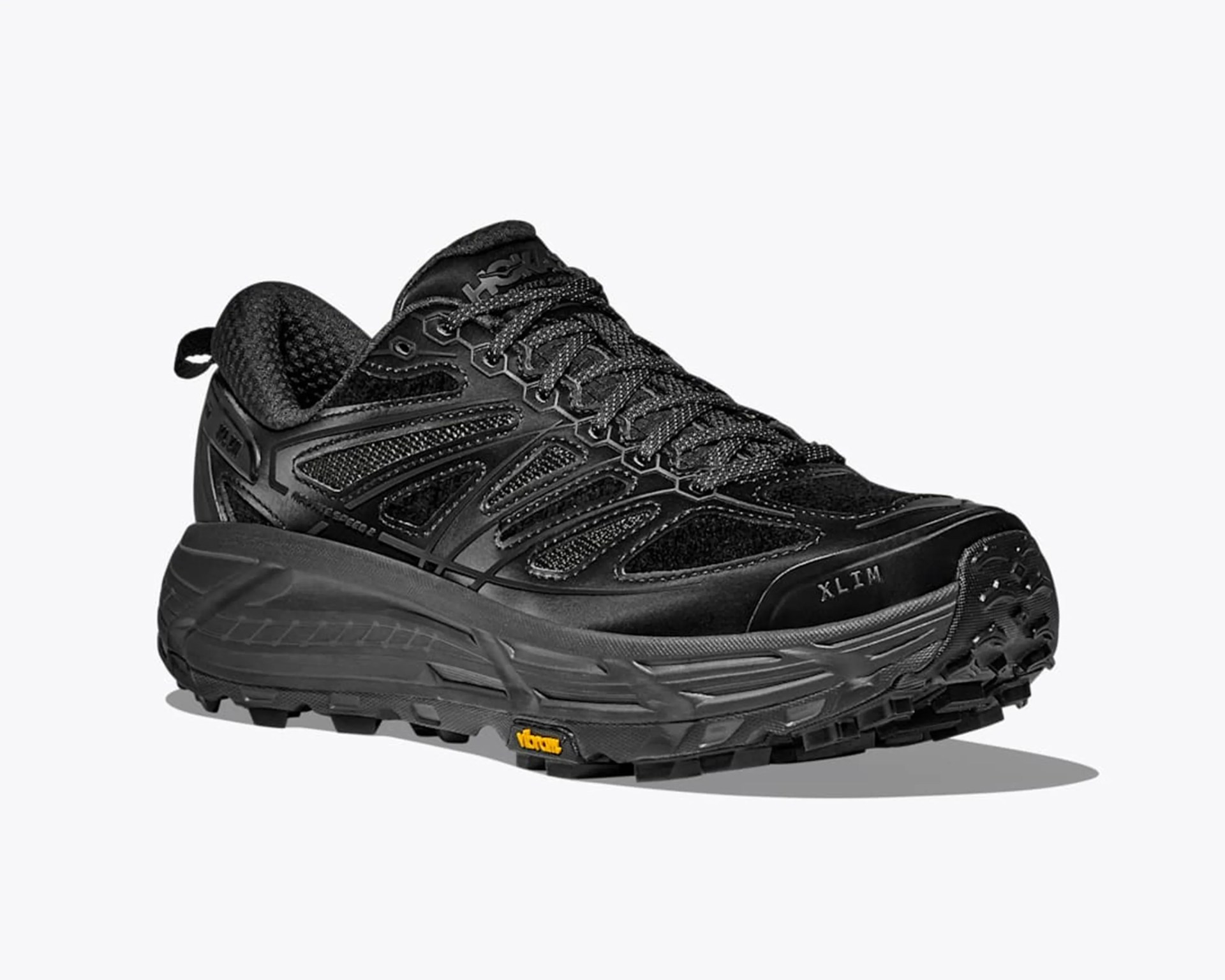 Black trail running shoe with thick sole, mesh and synthetic upper, and Vibram outsole.