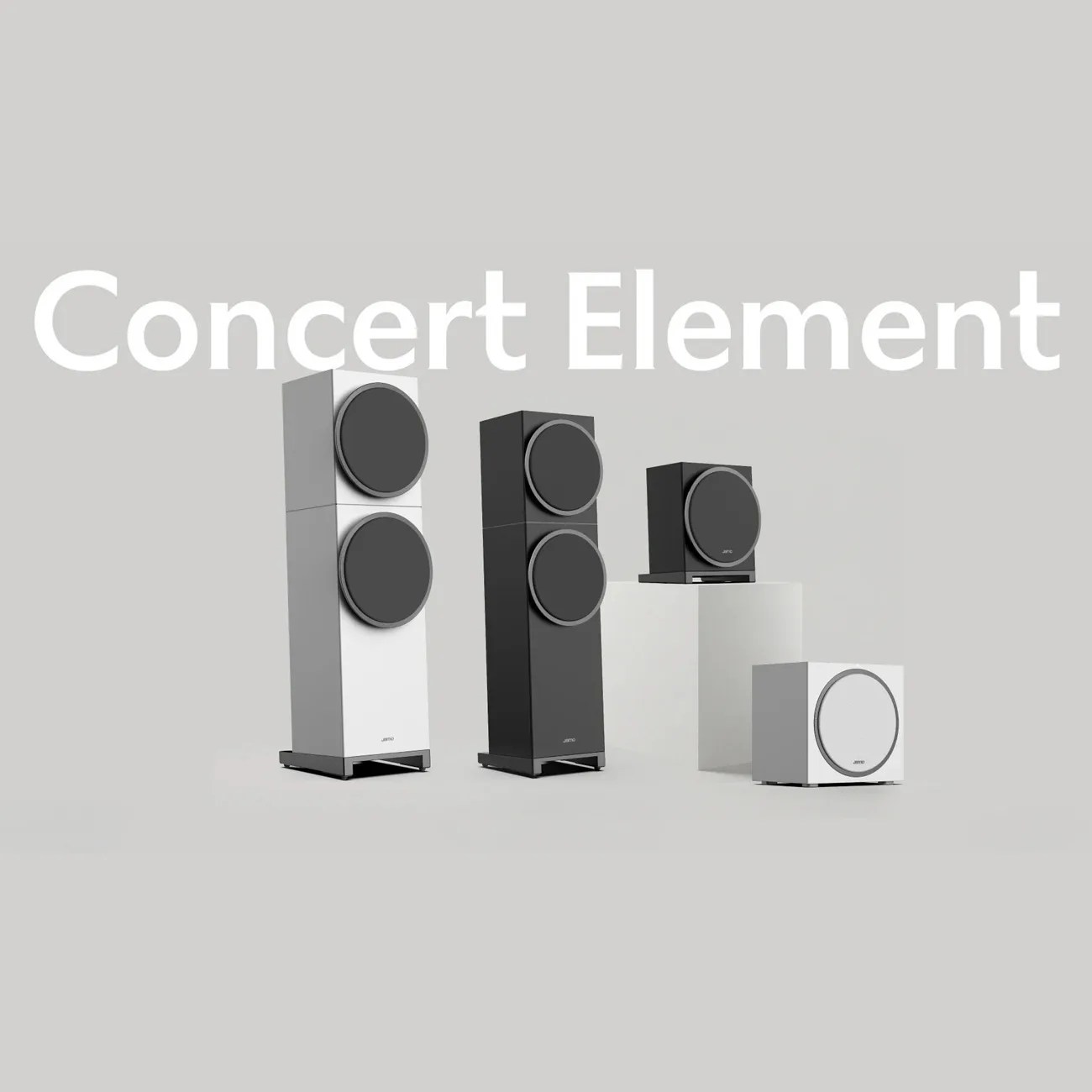 Four Jamo Concert Element speakers in black and white, including two tall floor-standing models and two smaller subwoofers, on a gray background.