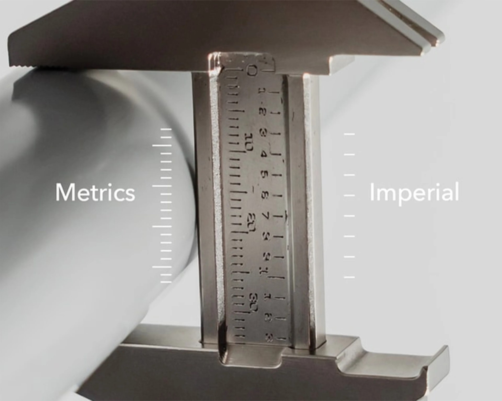 Close-up of a metal caliper showing both metric and imperial measurement scales.