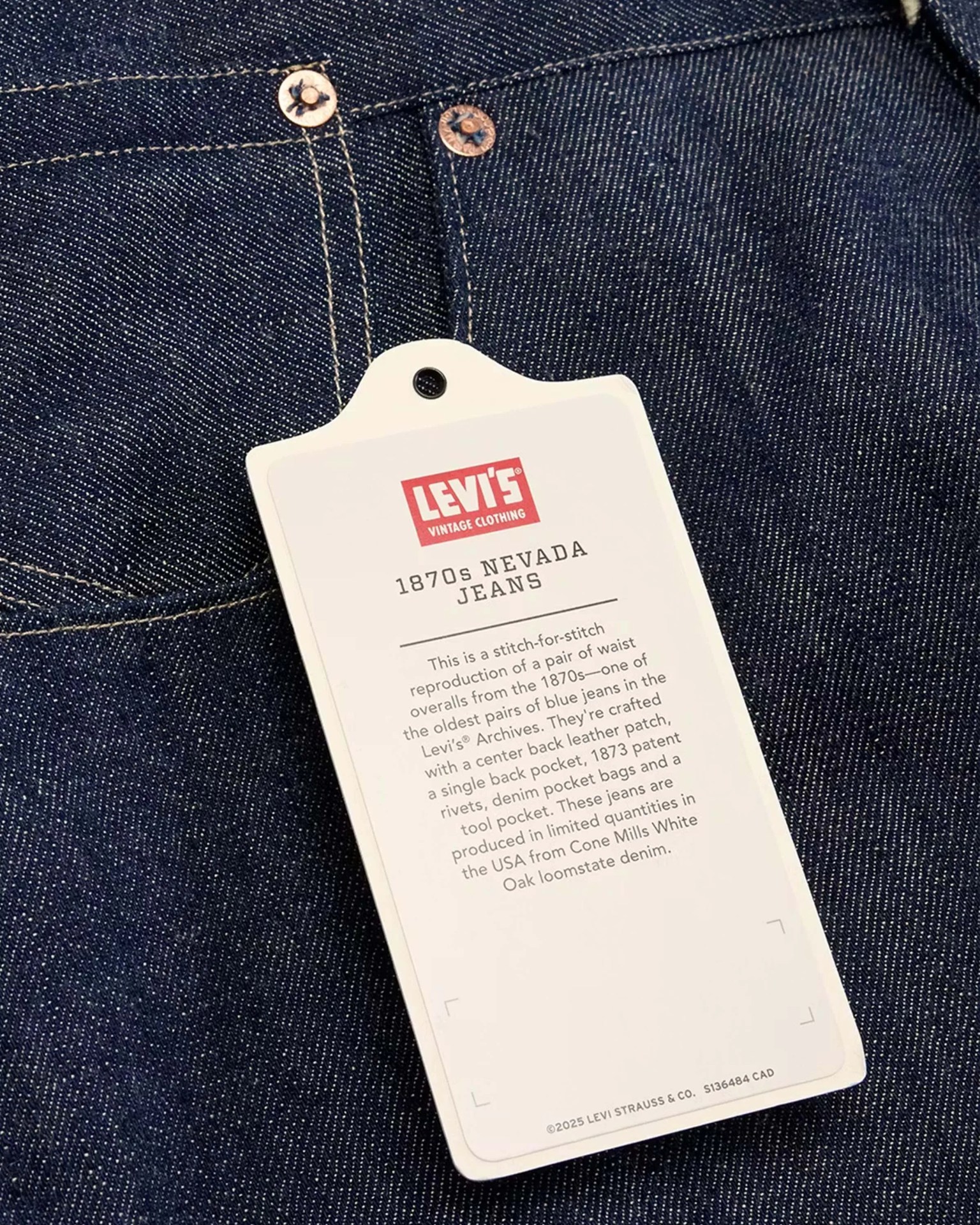 White Levi's Vintage Clothing tag labeled "1870s Nevada Jeans" on dark blue denim fabric.