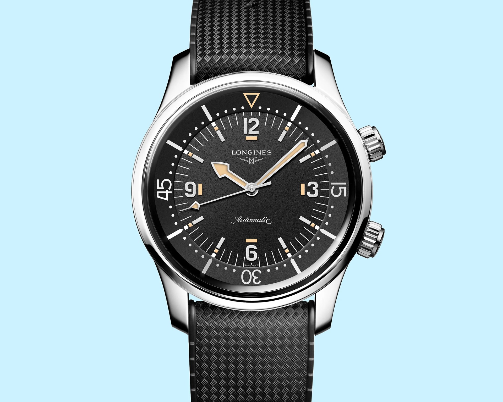 Black Longines automatic watch with silver case and textured black strap on light blue background.