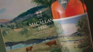 Close-up of The Macallan 1986 Highland Single Malt Scotch Whisky bottle and its box featuring a pastoral landscape with cows and trees.
