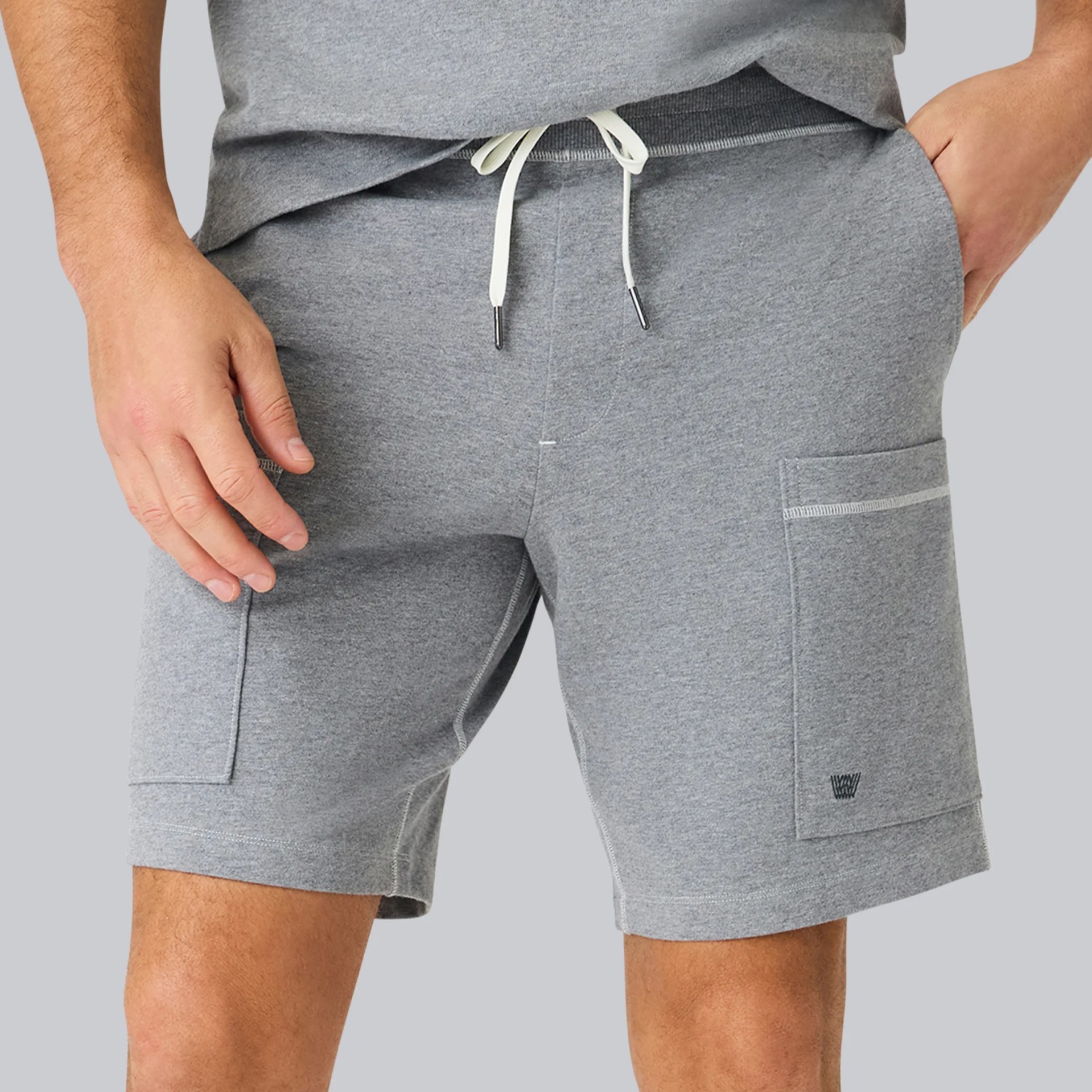 Gray drawstring shorts with side pockets worn by a person.