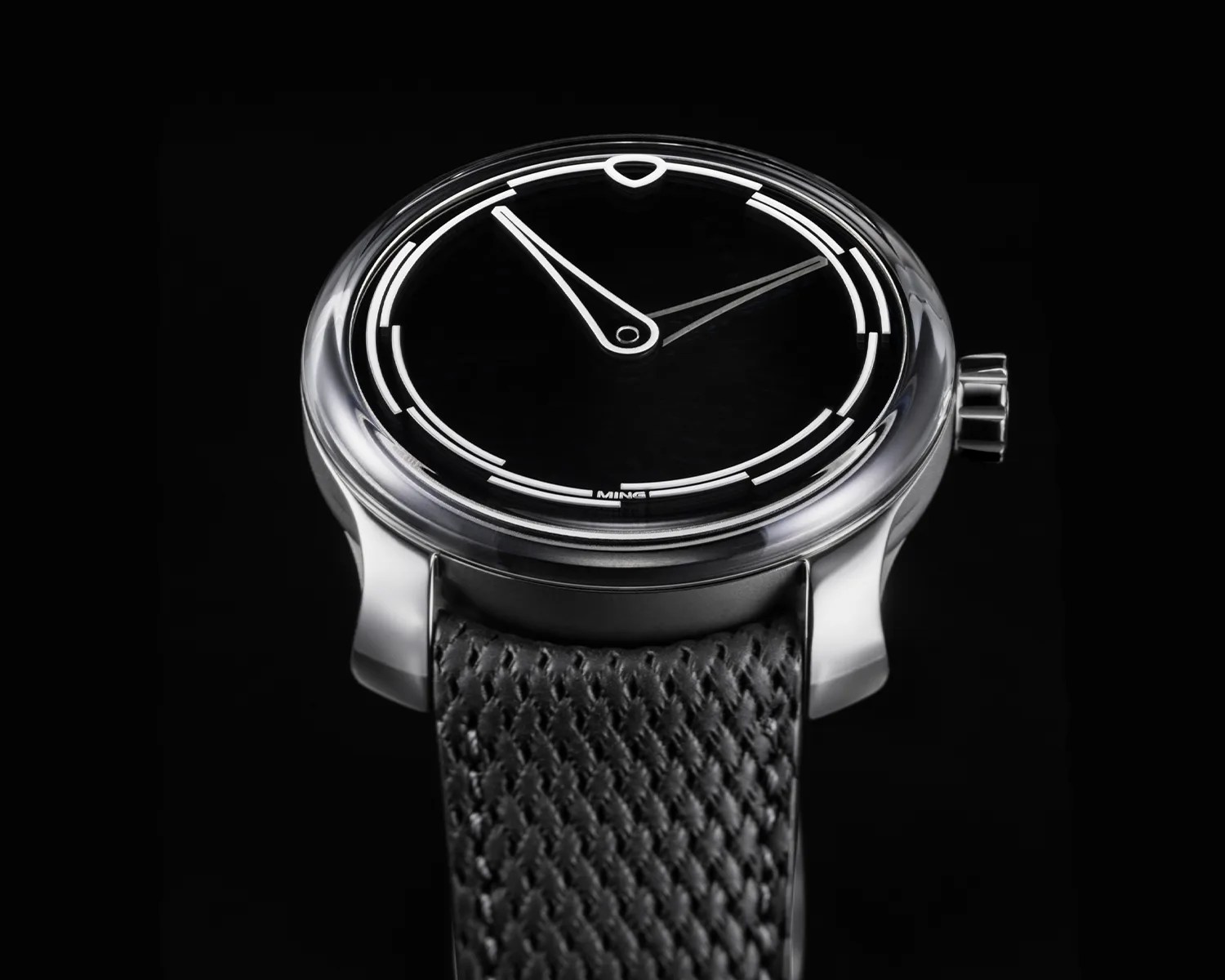 Black dial wristwatch with white minimalist hour markers and a textured black strap.
