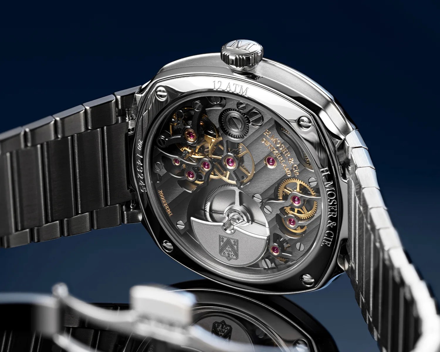 Back view of a stainless steel H. Moser & Cie watch showing intricate mechanical movement and bracelet.