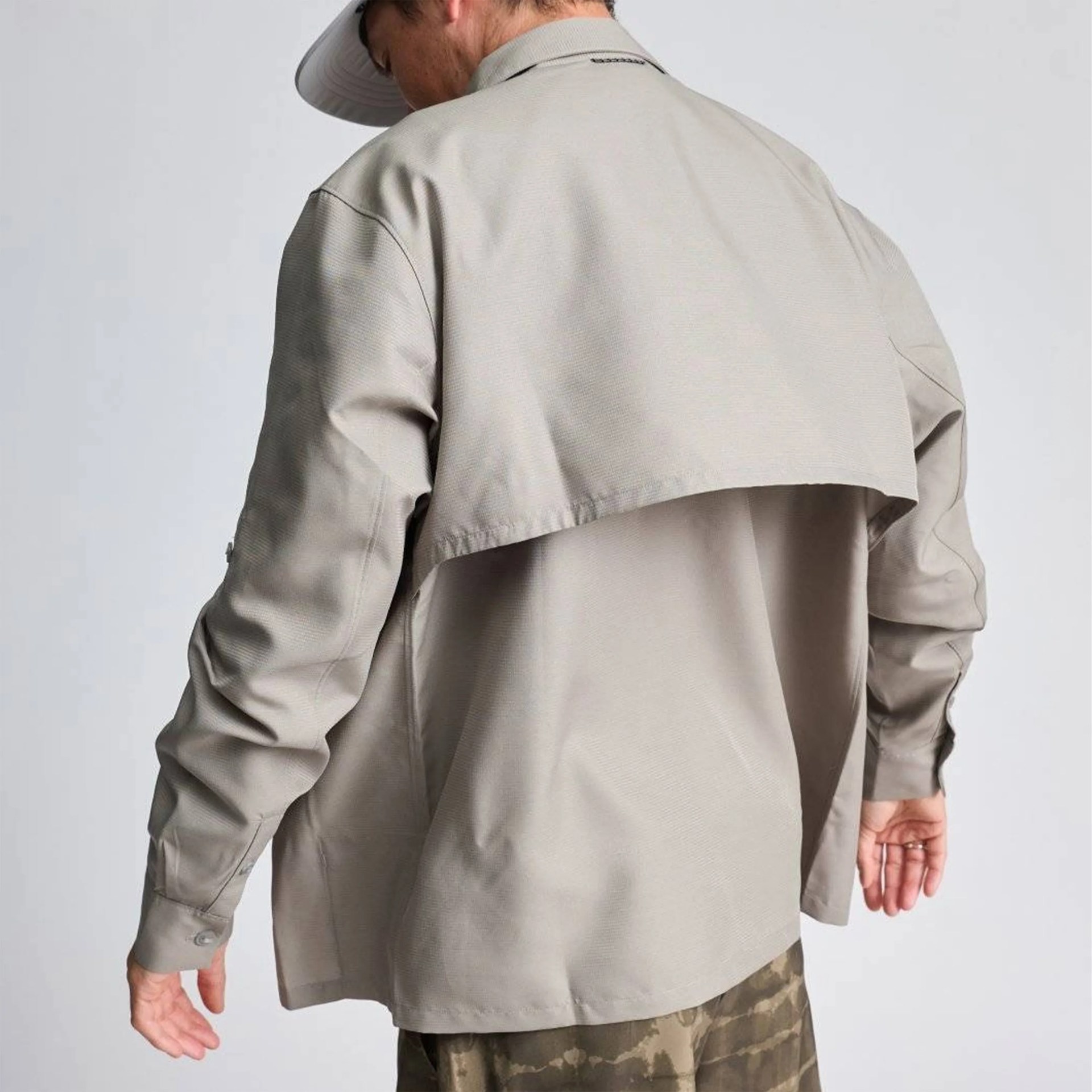 Light beige long-sleeve shirt with a back yoke flap worn by a person.