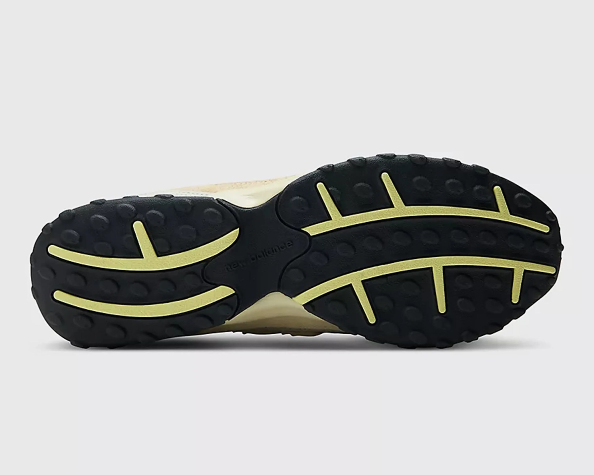 Black and yellow rubber sole of a New Balance shoe with textured grip pattern.