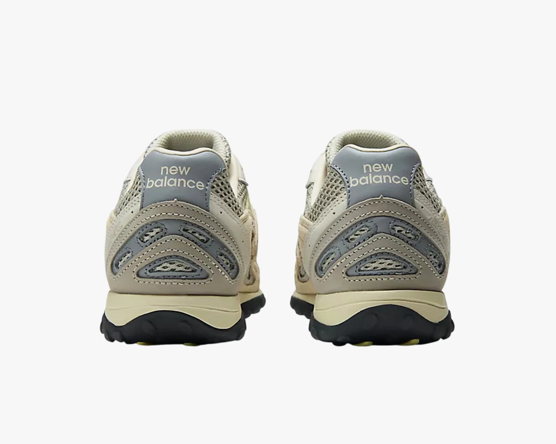Pair of beige and gray New Balance sneakers shown from the back with black soles.