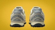 Pair of beige and gray New Balance sneakers shown from the back on a yellow background.