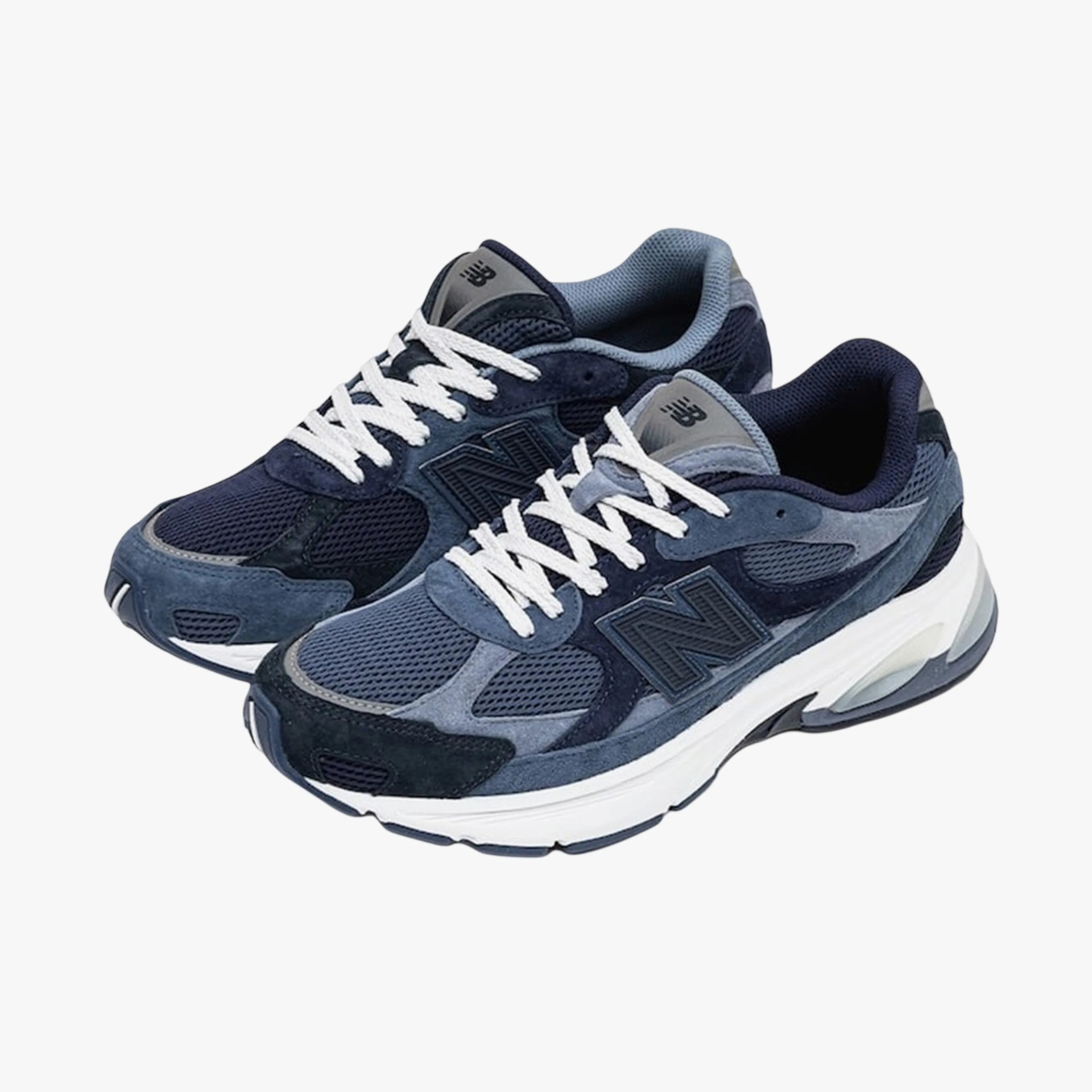 Pair of navy and blue New Balance sneakers with white laces and thick white soles.