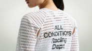 White mesh top with large holes and black text reading "ALL CONDITIONS Racing Dept." on the back, worn by a person.