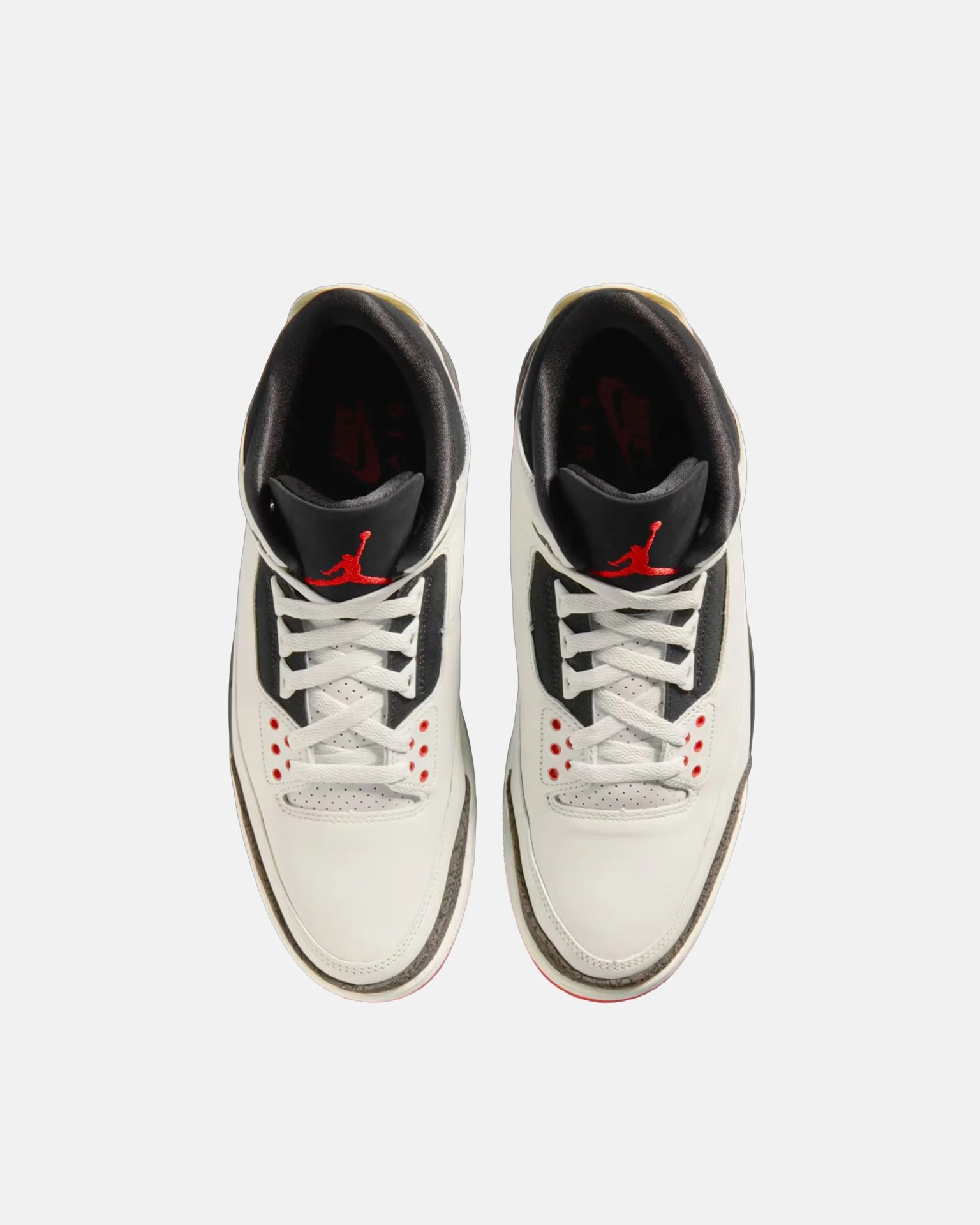 Pair of white and black Air Jordan sneakers with red Jumpman logo on black tongues, viewed from above.