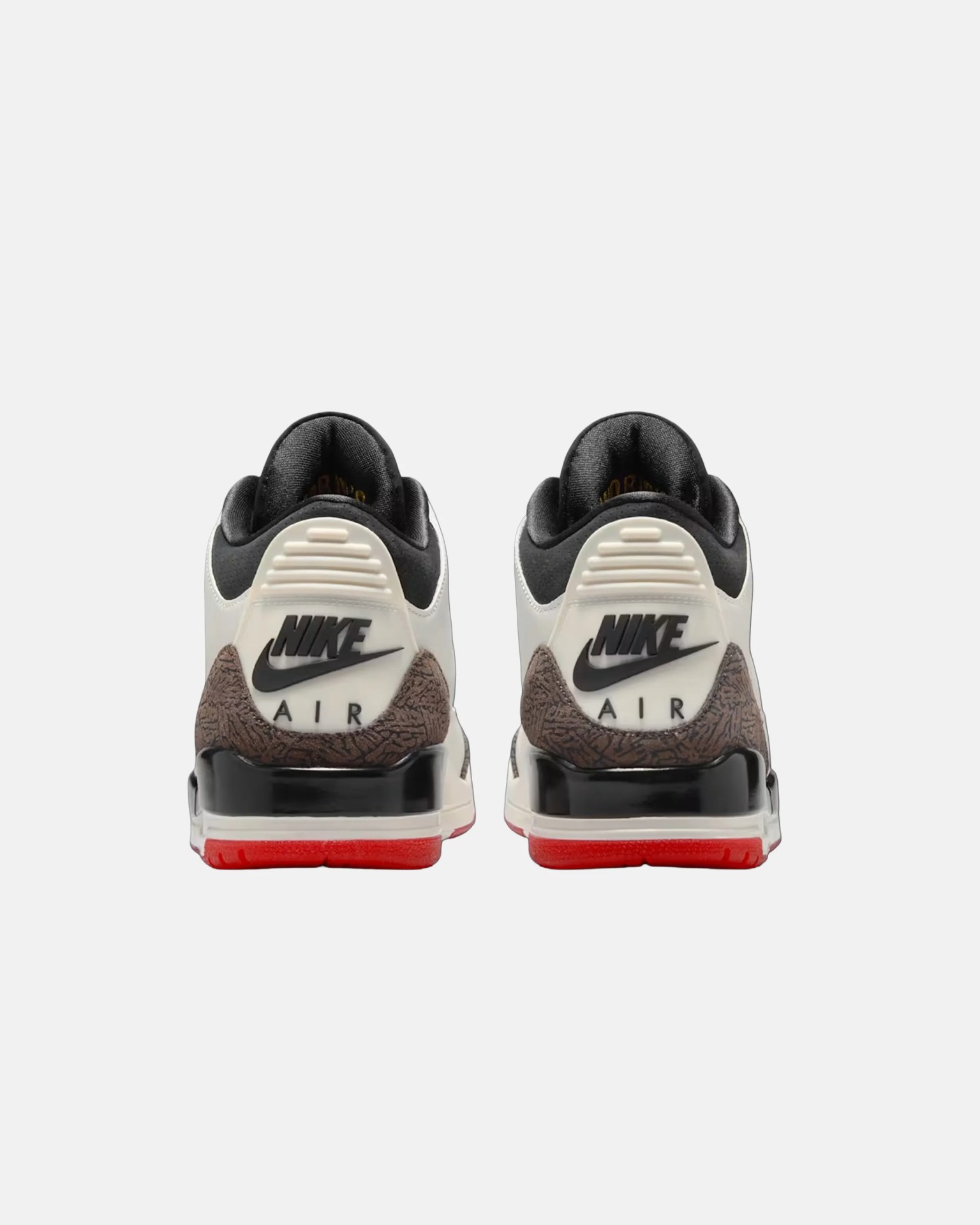 Pair of white and black Nike Air sneakers with red soles shown from the back.