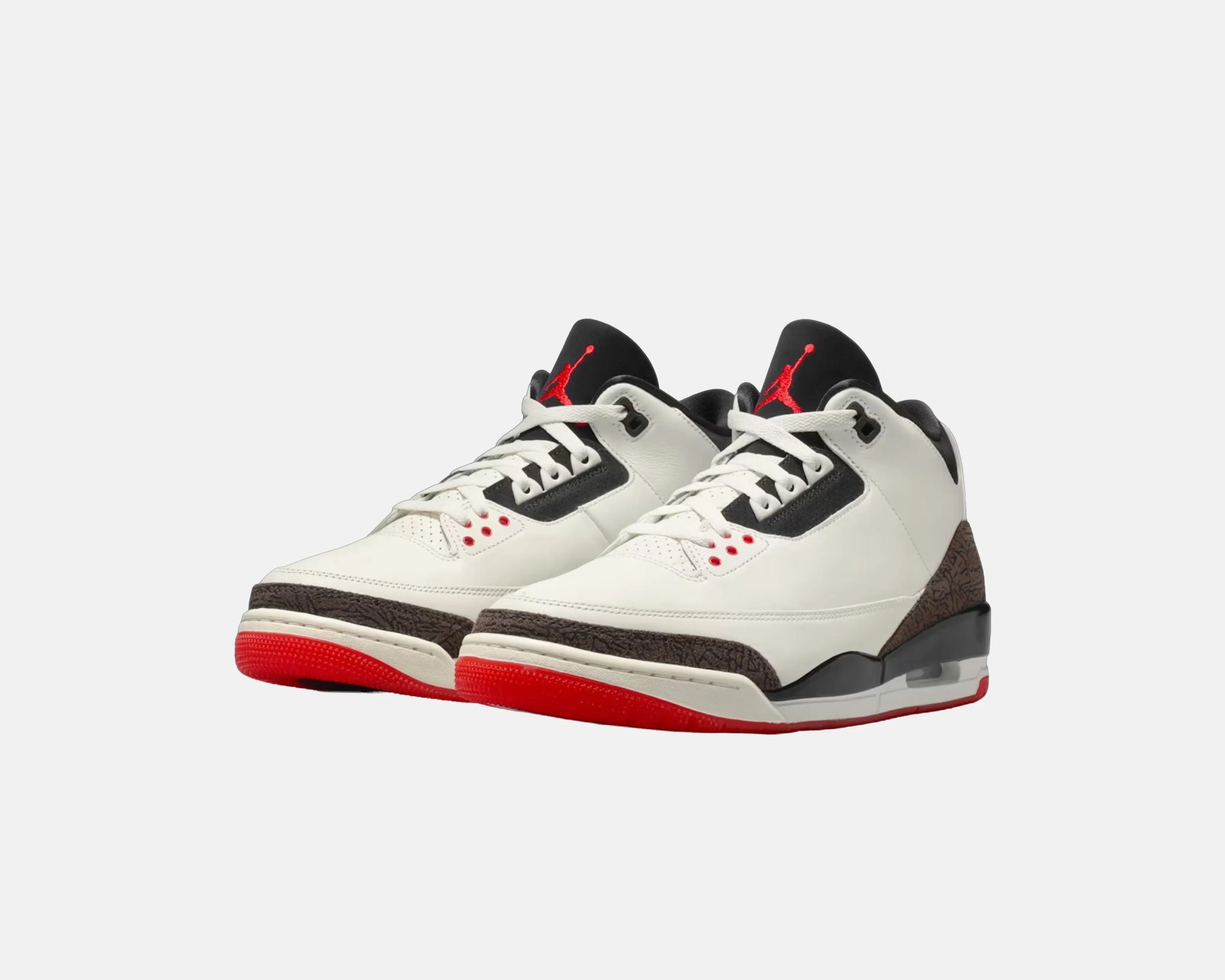 White and black Air Jordan sneakers with red soles and red Jumpman logos on black tongues.