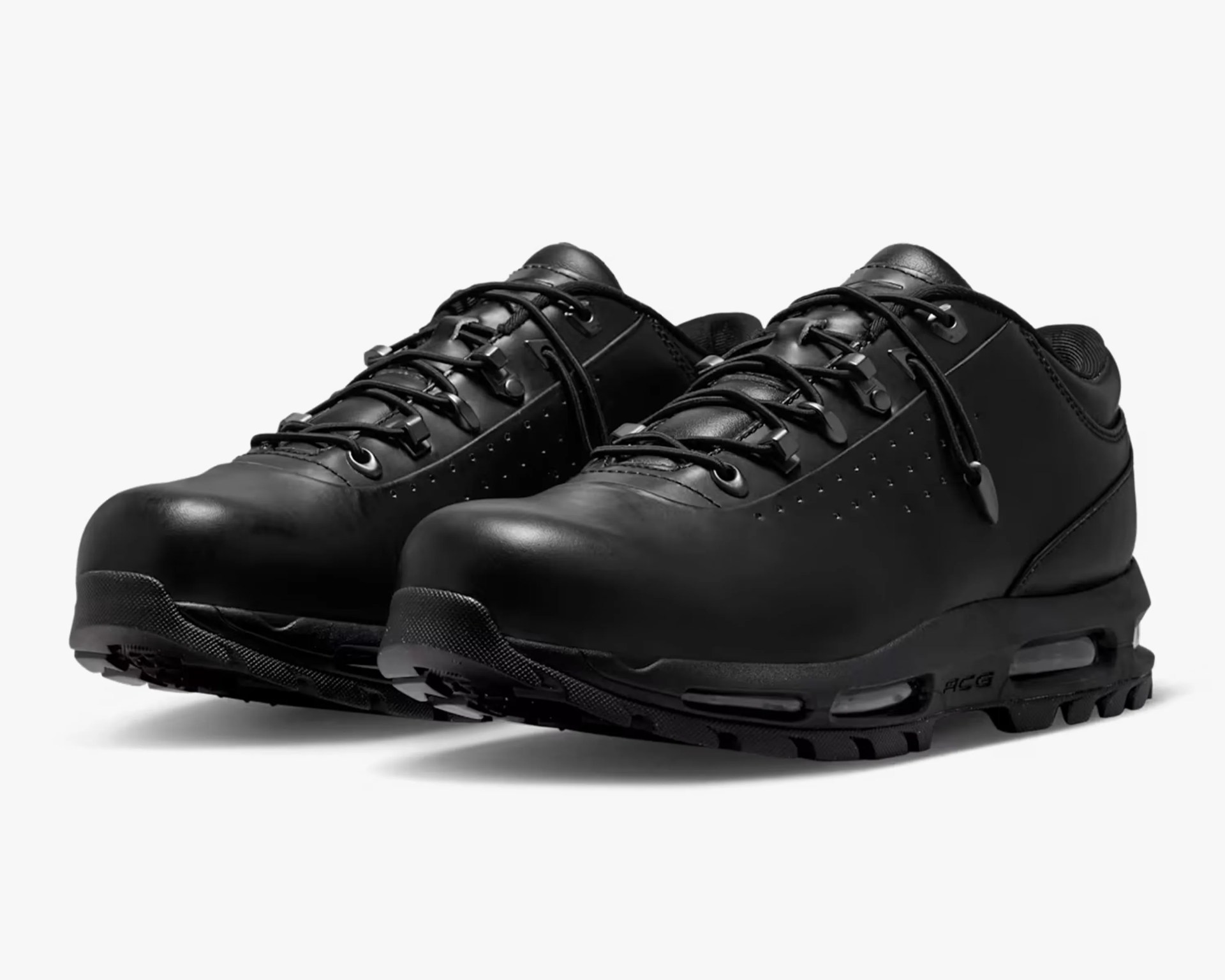 Black leather shoe with perforated side panels and metal eyelets for laces.