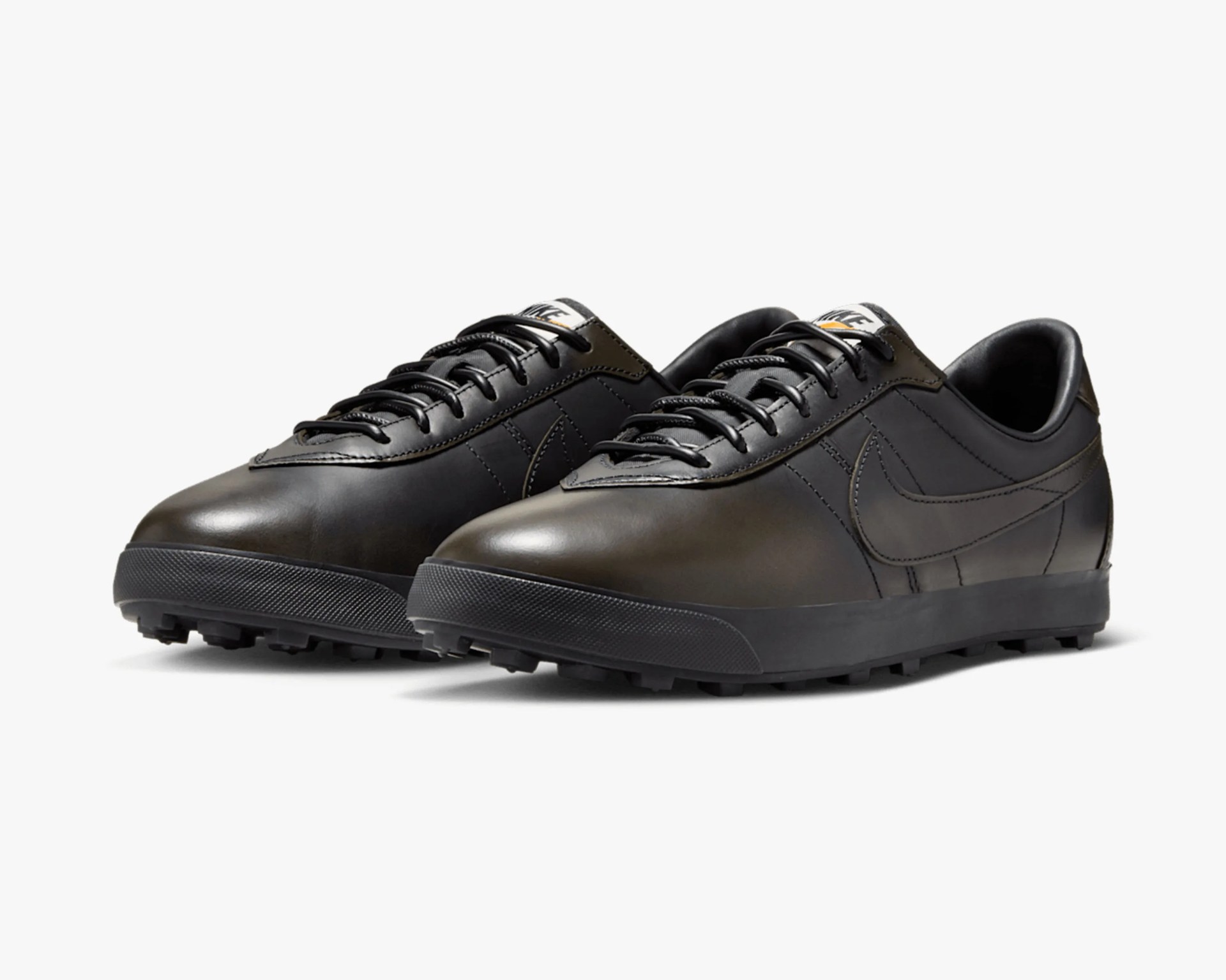 Pair of black leather Nike sneakers with black laces and textured rubber soles.