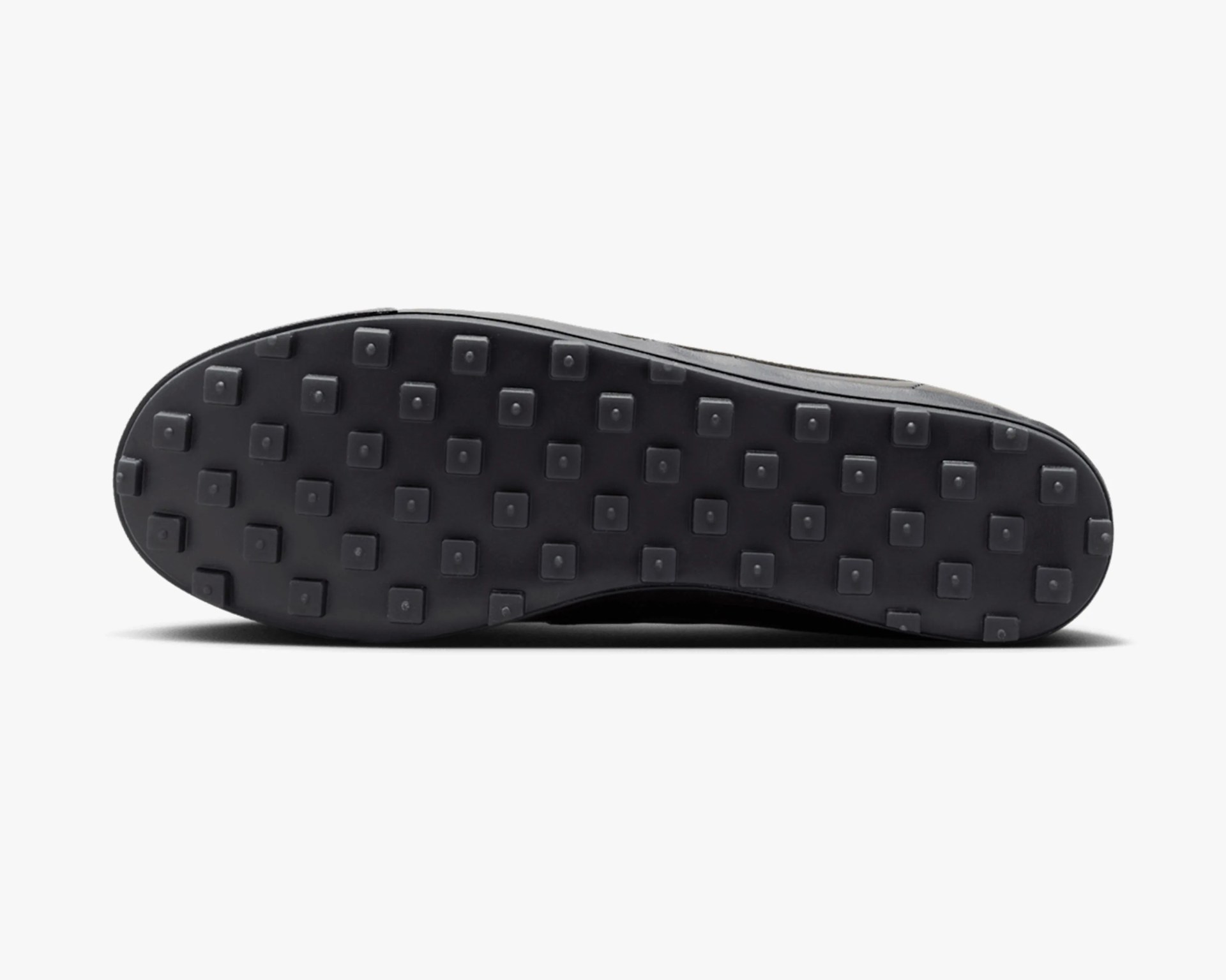 Black shoe sole with square-shaped rubber studs arranged in a grid pattern.