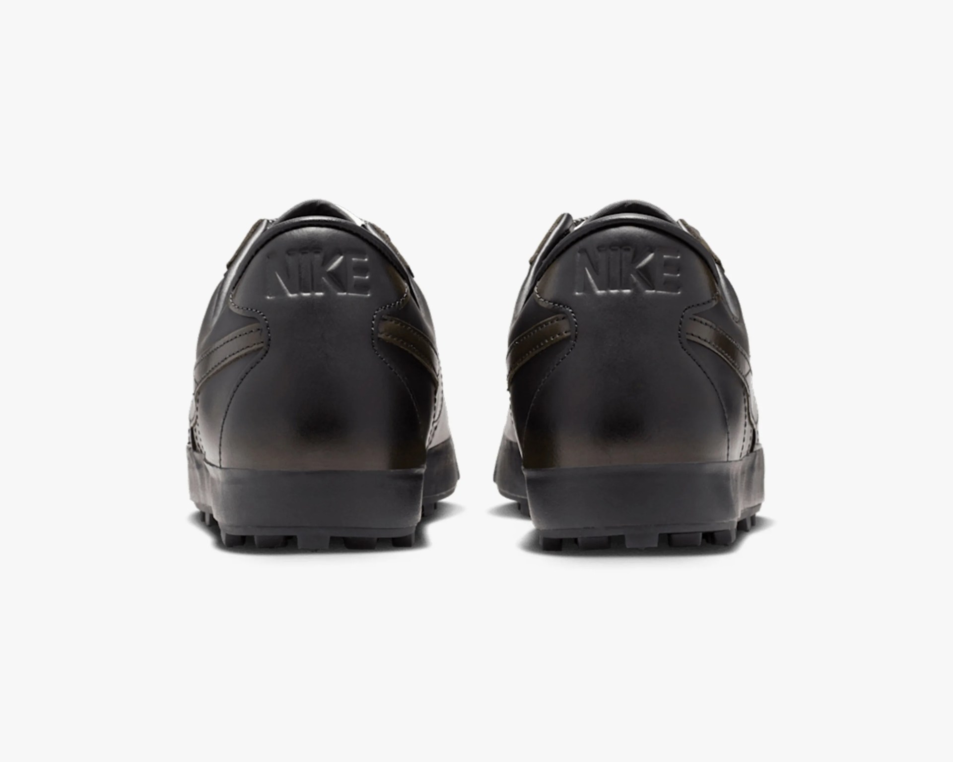 Pair of black Nike shoes shown from the back with embossed Nike logo on the heel.