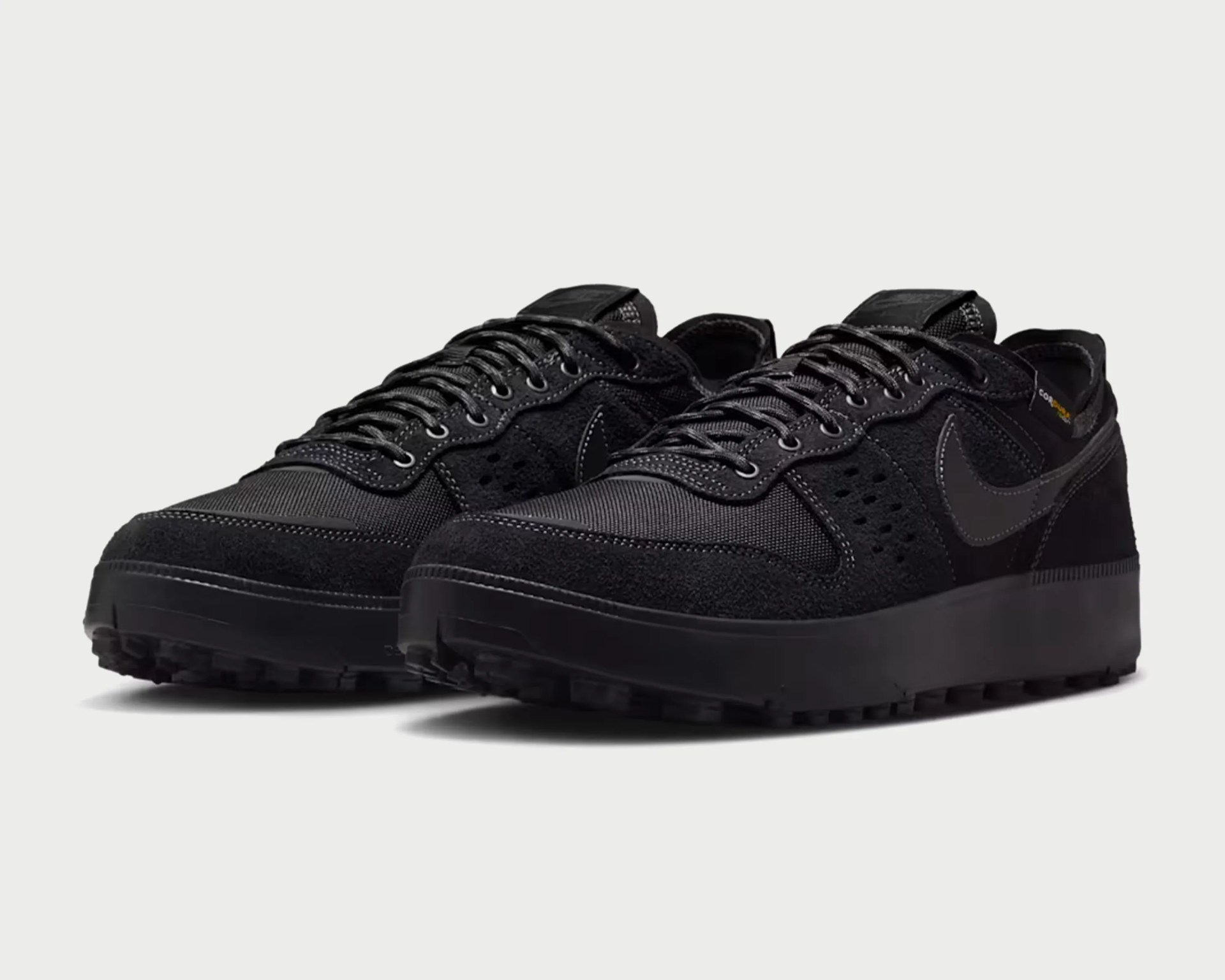Pair of black Nike sneakers with textured suede and mesh uppers and rugged rubber soles.