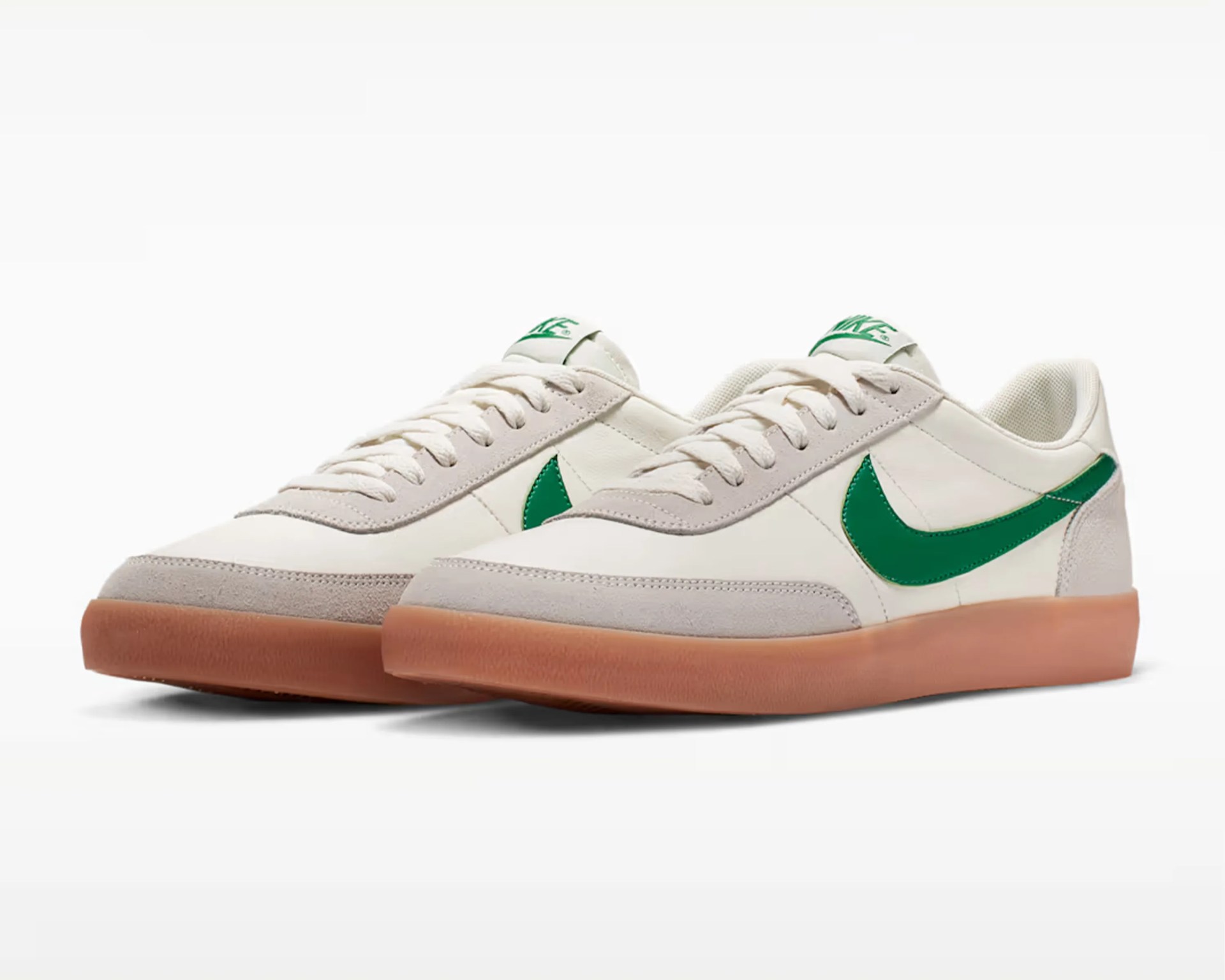 Pair of white Nike sneakers with green swoosh logos and gum rubber soles.