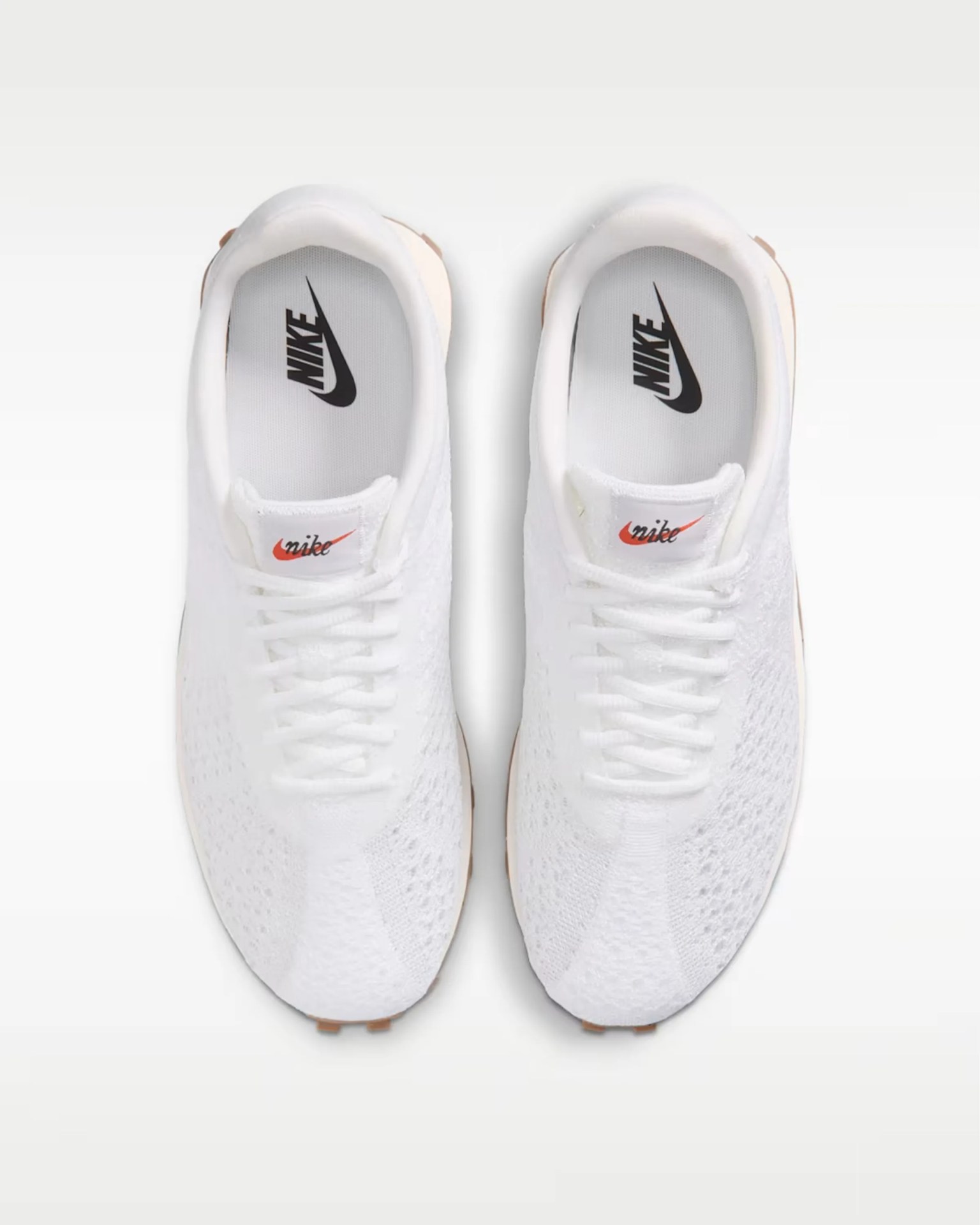 White knitted low-top sneaker with gum sole and white laces on a white background.