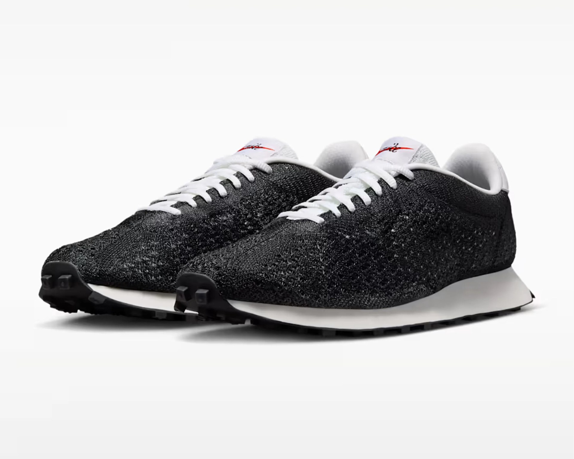 black knitted low-top sneaker with gum sole and white laces on a white background.