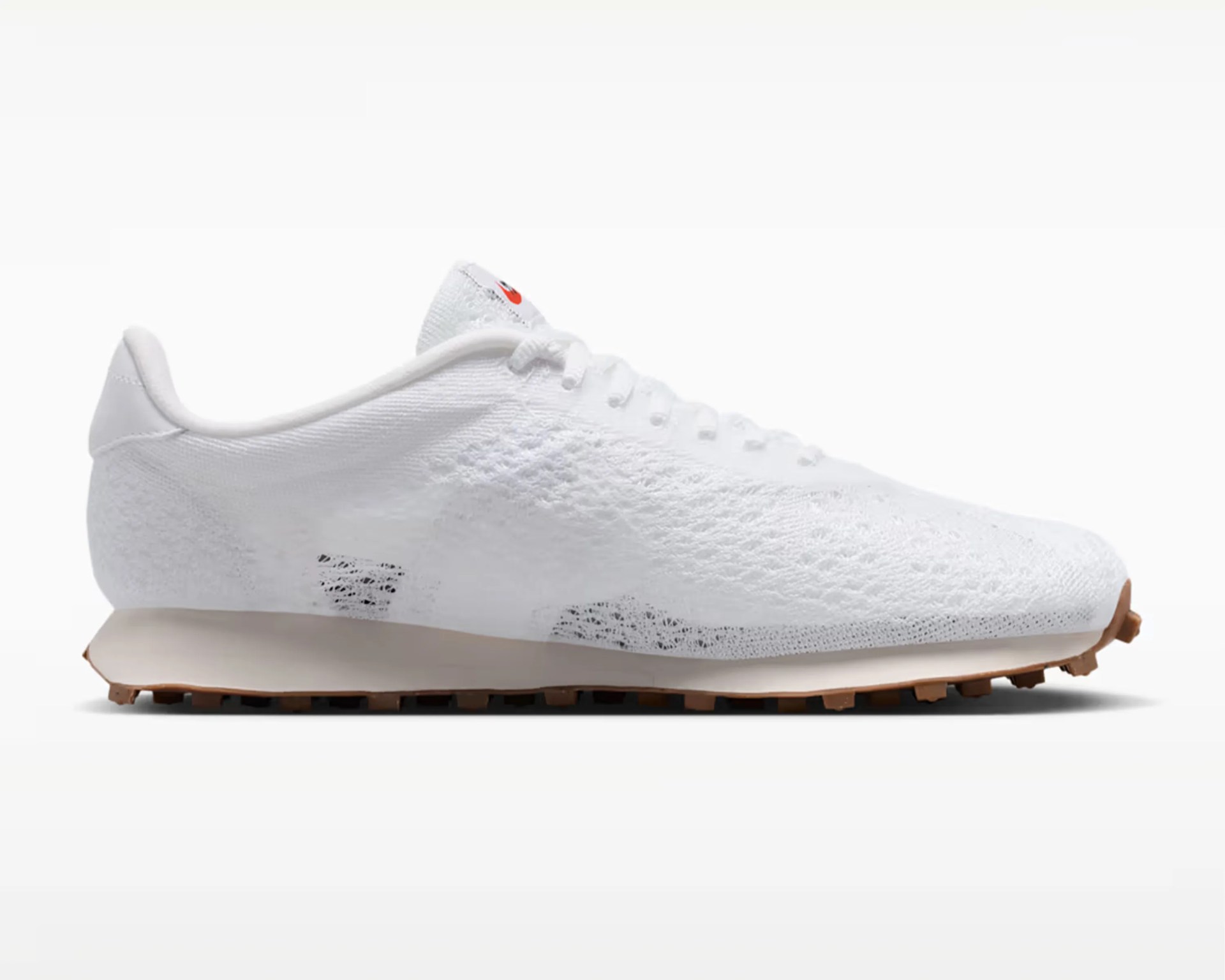 White knitted low-top sneaker with gum sole and white laces on a white background.