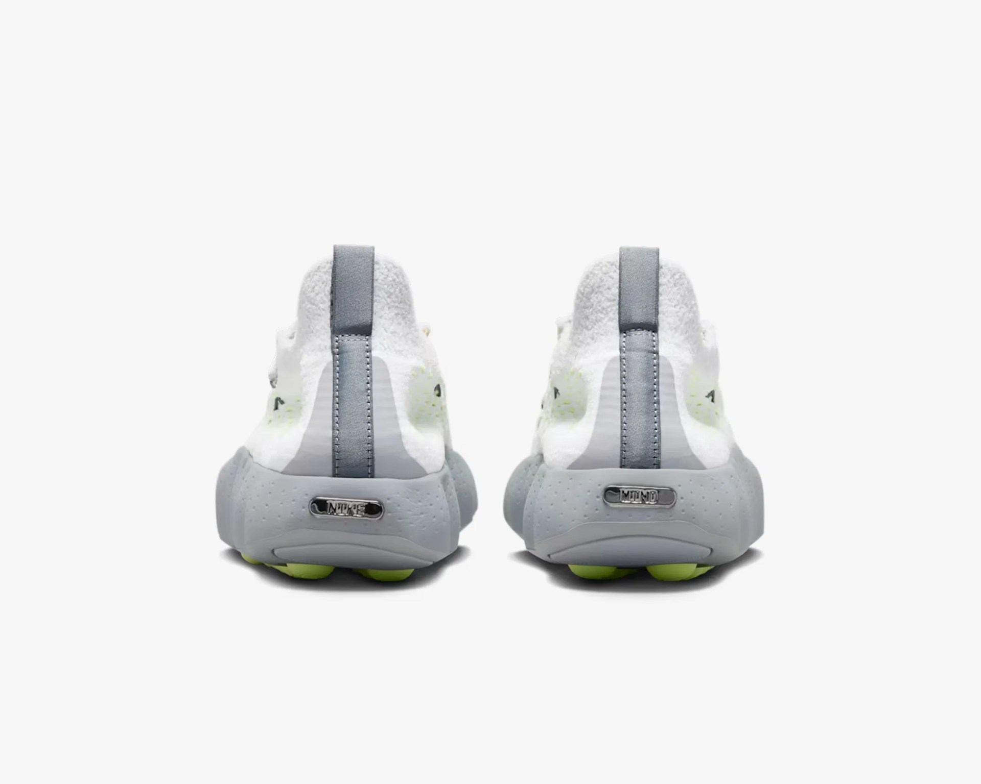 Rear view of white and gray Nike sneakers with textured fabric and neon green outsole accents.