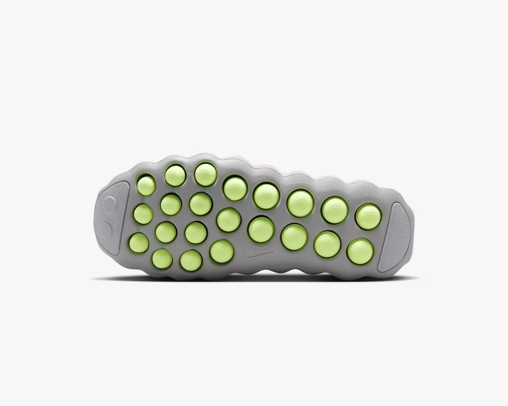 Gray shoe sole with multiple round lime green traction pods and a small Nike swoosh logo.