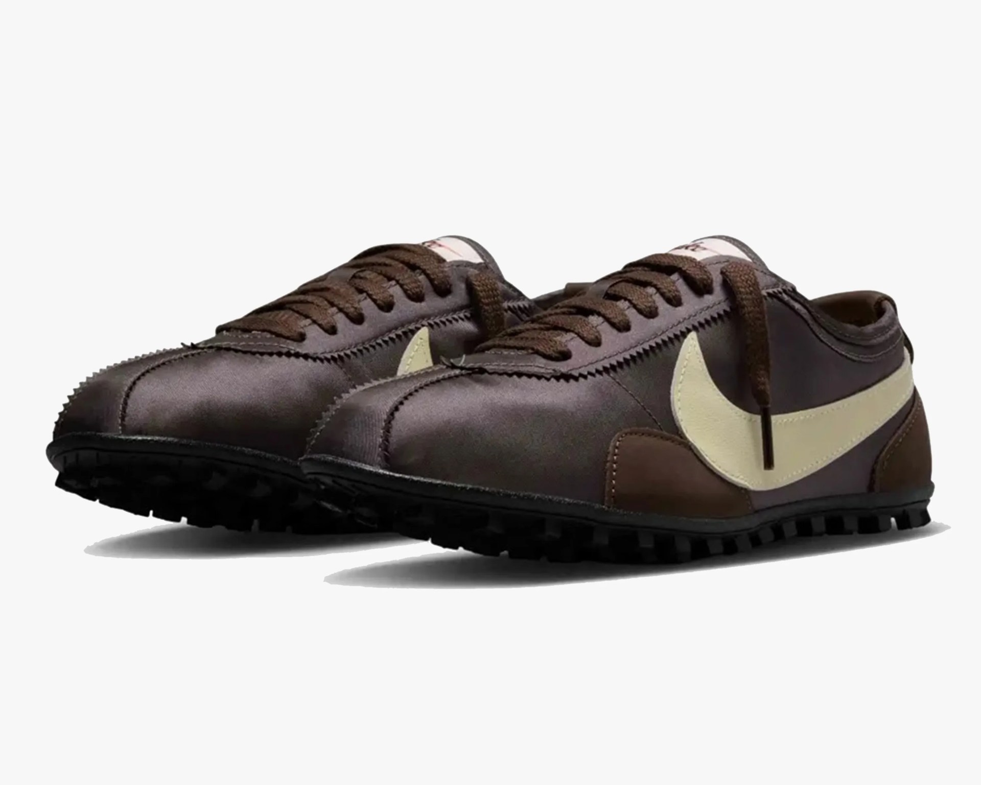 Pair of brown Nike sneakers with cream-colored swoosh logos and black soles.